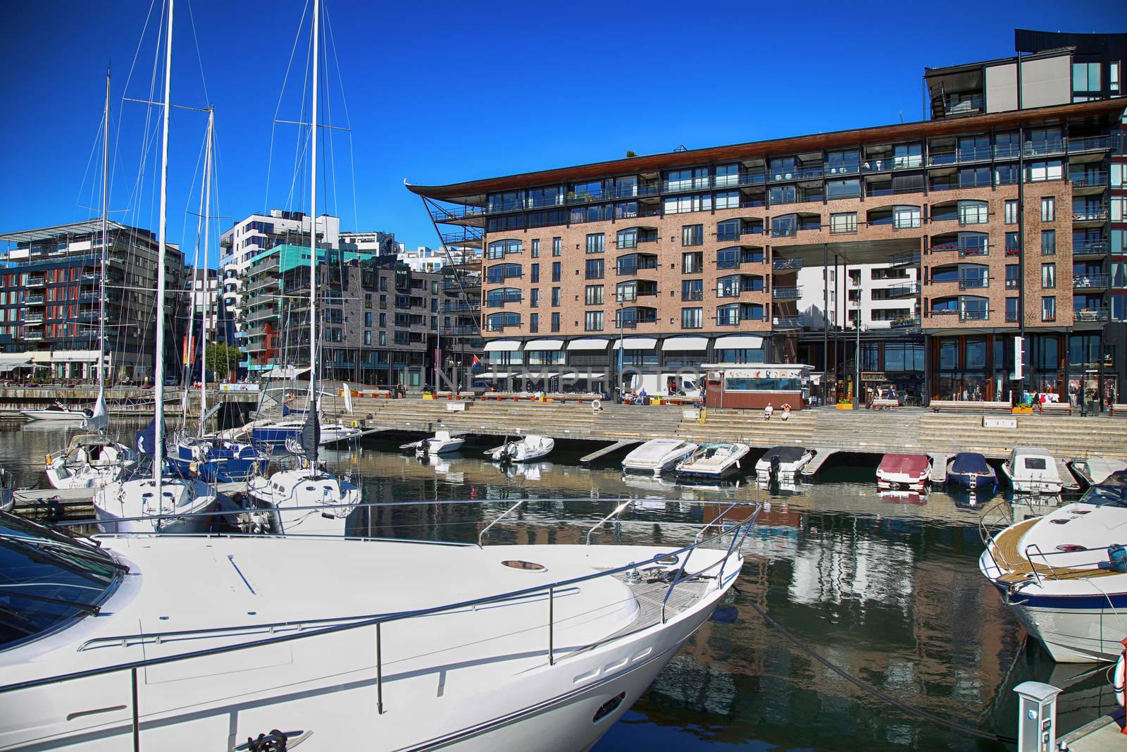 OSLO, NORWAY – AUGUST 17, 2016: People walking on modern district on street Stranden, Aker Brygge district with lux apartments, yacht; culture and restaurants in Oslo, Norway on August 17,2016.