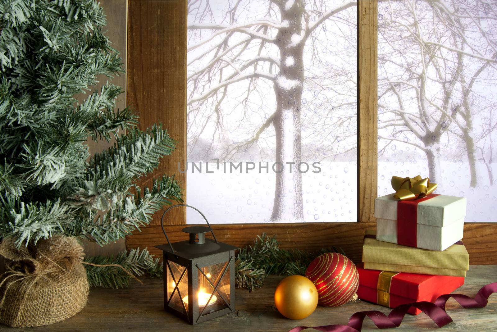 Christmas gifts and decorations next to a window with snow outdoors