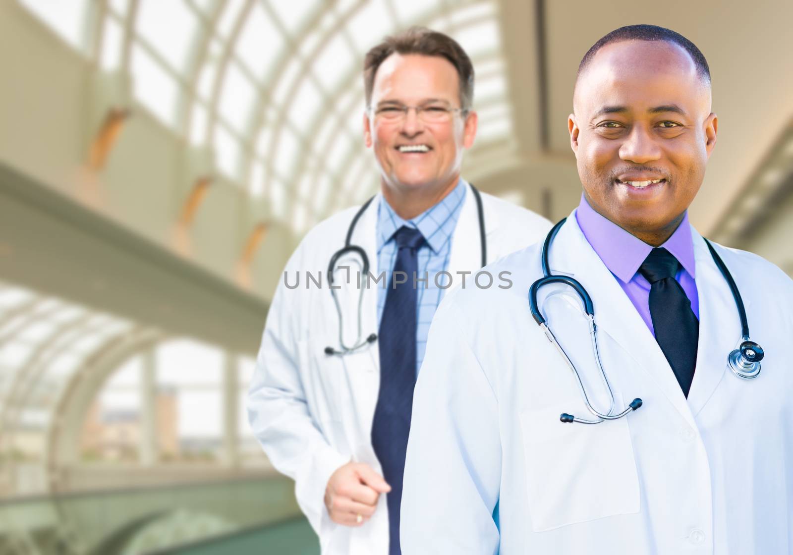African American and Caucasian Male Doctors Inside Hospital Office.