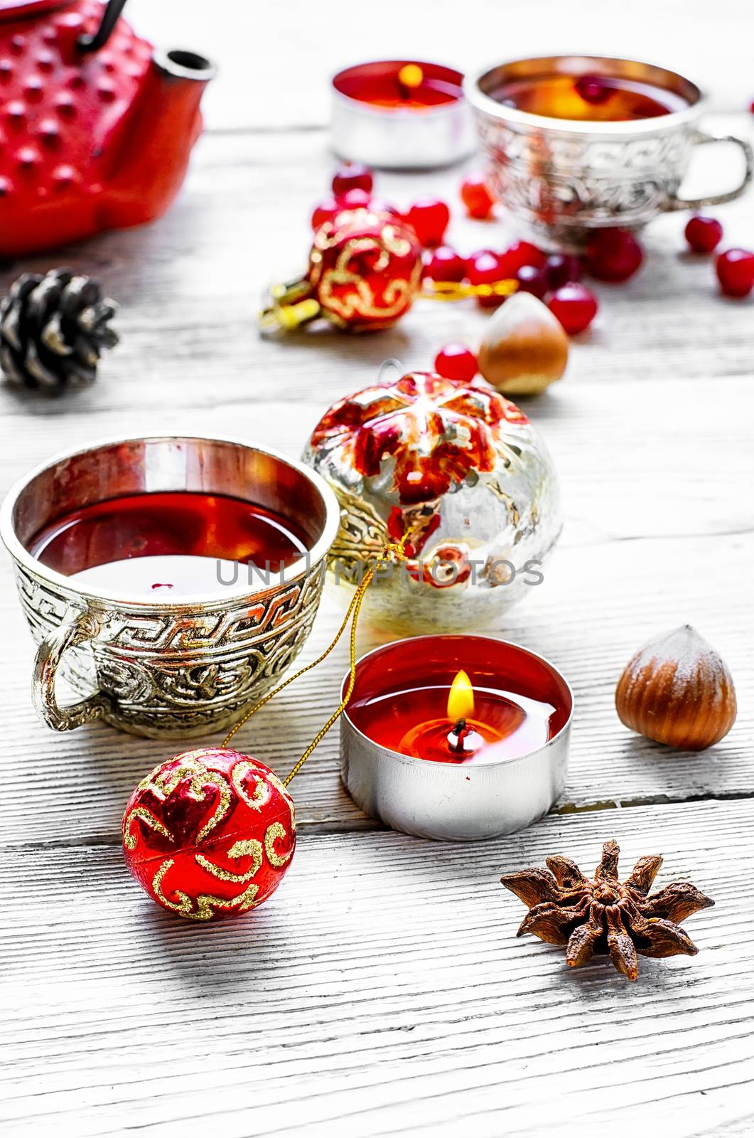 Kettle,cranberry tea and Christmas toy on light background
