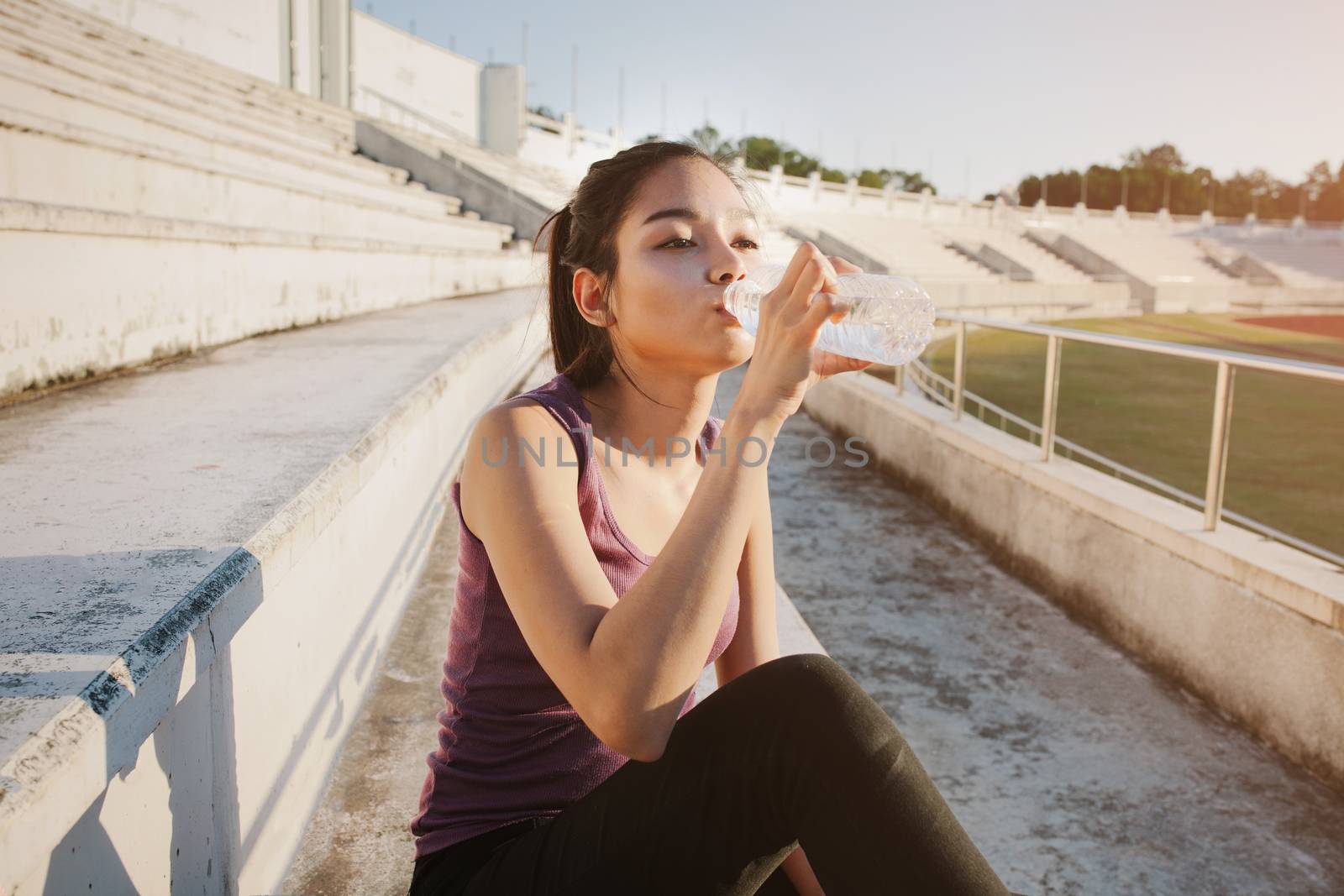 Woman relaxing after sports and drinking water by nopparats