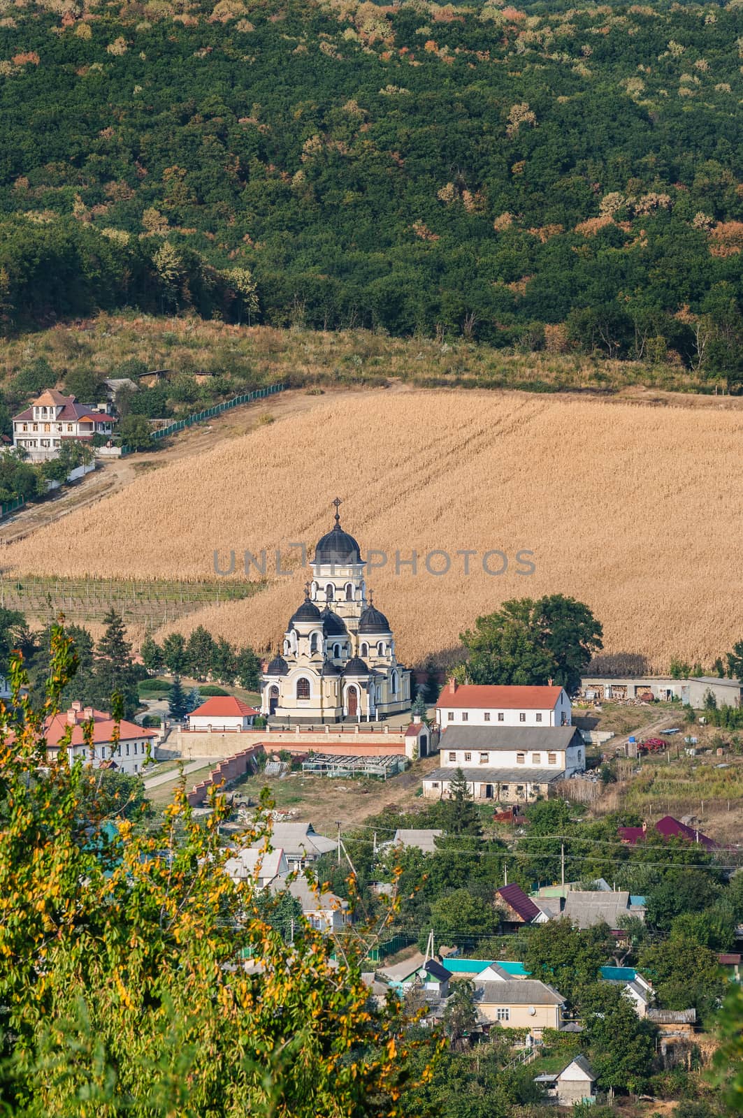 Landscape view with Capriana Monastery and the village around. Winter Church visible at center was built in Neo-Byzantine style in 1903. Capriana Orthodox Christian Monastery is one of the oldest monasteries of Moldova, first time mentioned in 1429.