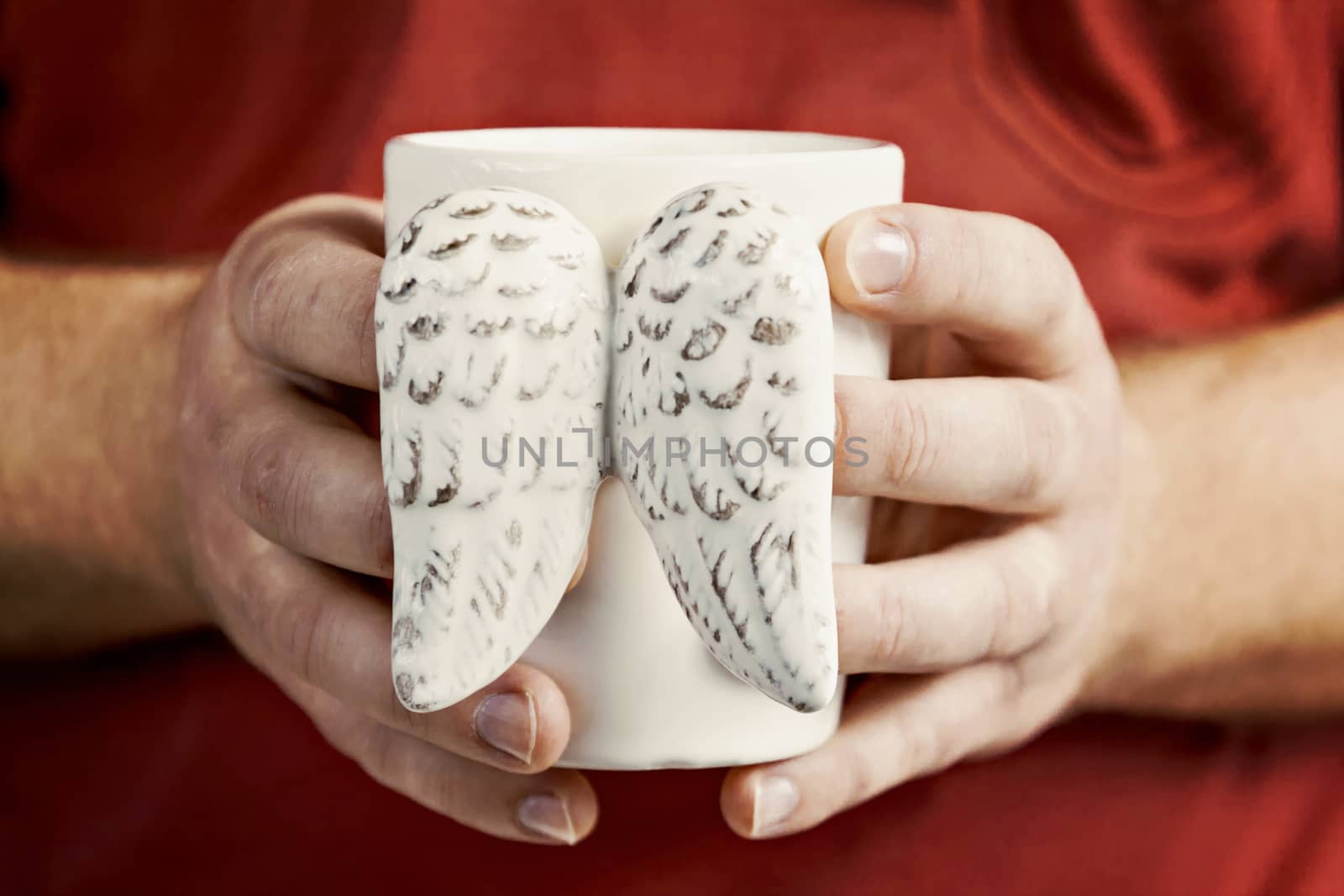 man's hand holding a cup of vintage shabby wings close-up.