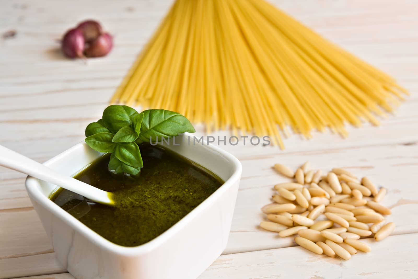 Closeup of pesto genovese and linguine pasta, pine nuts and garlic on a table
