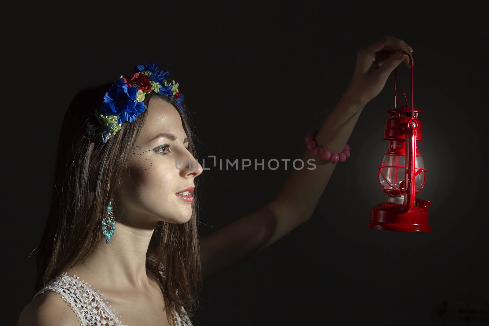 Portrait of a girl in a wreath of flowers on a dark background