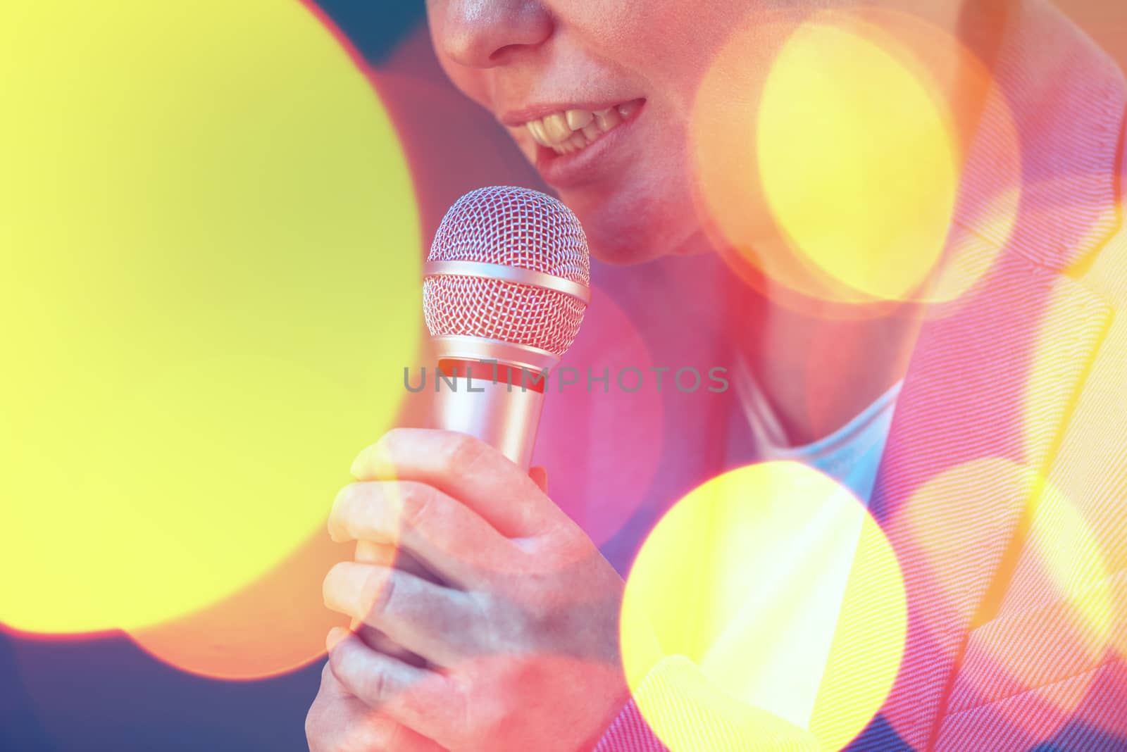 Beautiful woman singing karaoke song with microphone by stevanovicigor