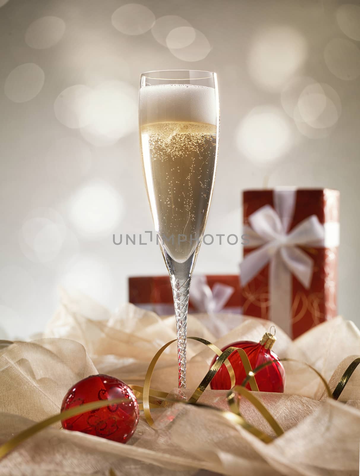 Christmas glasses of Champagne and golden background with red gifts