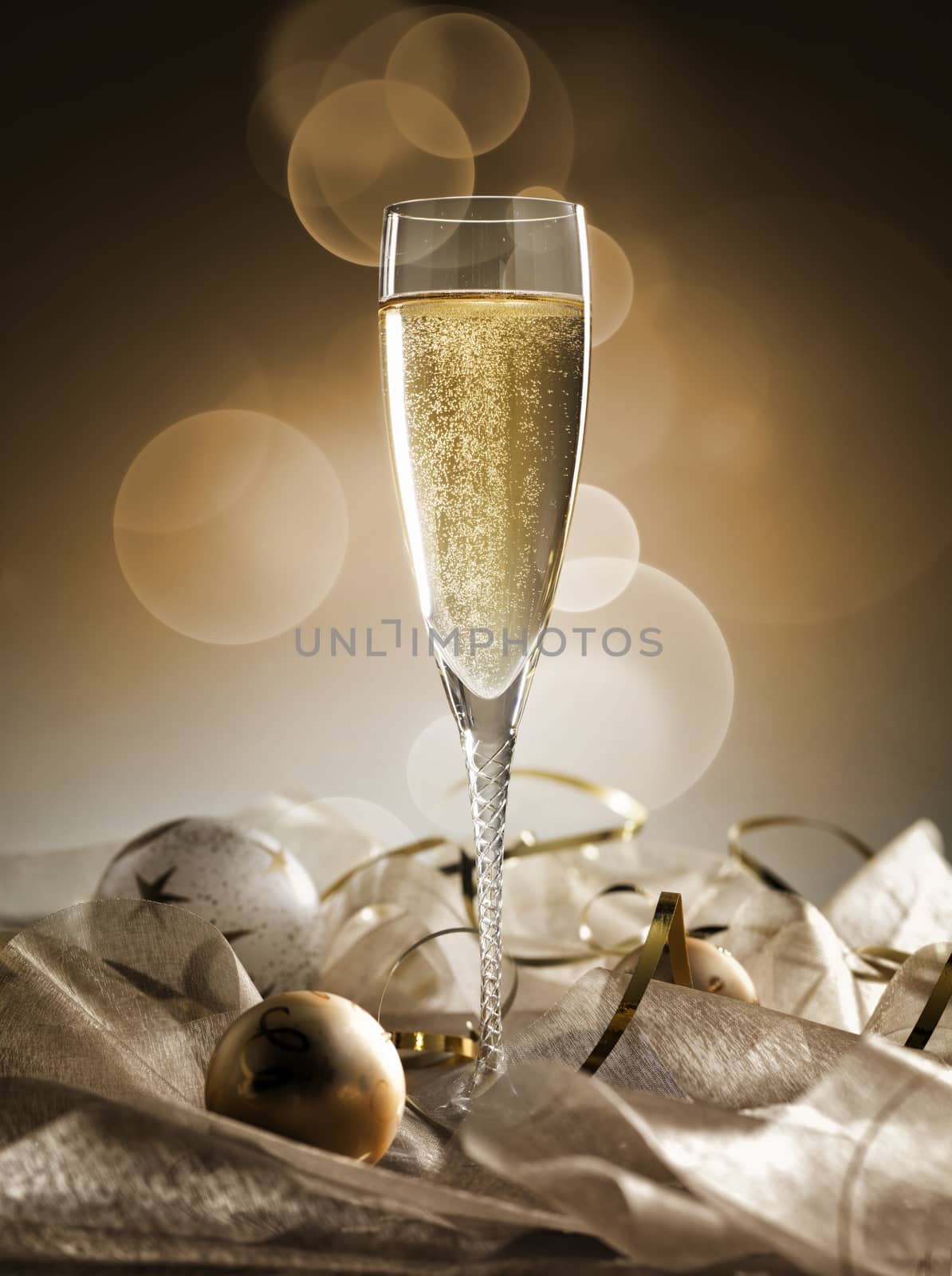 One champagne glass and decoration on golden and silver background