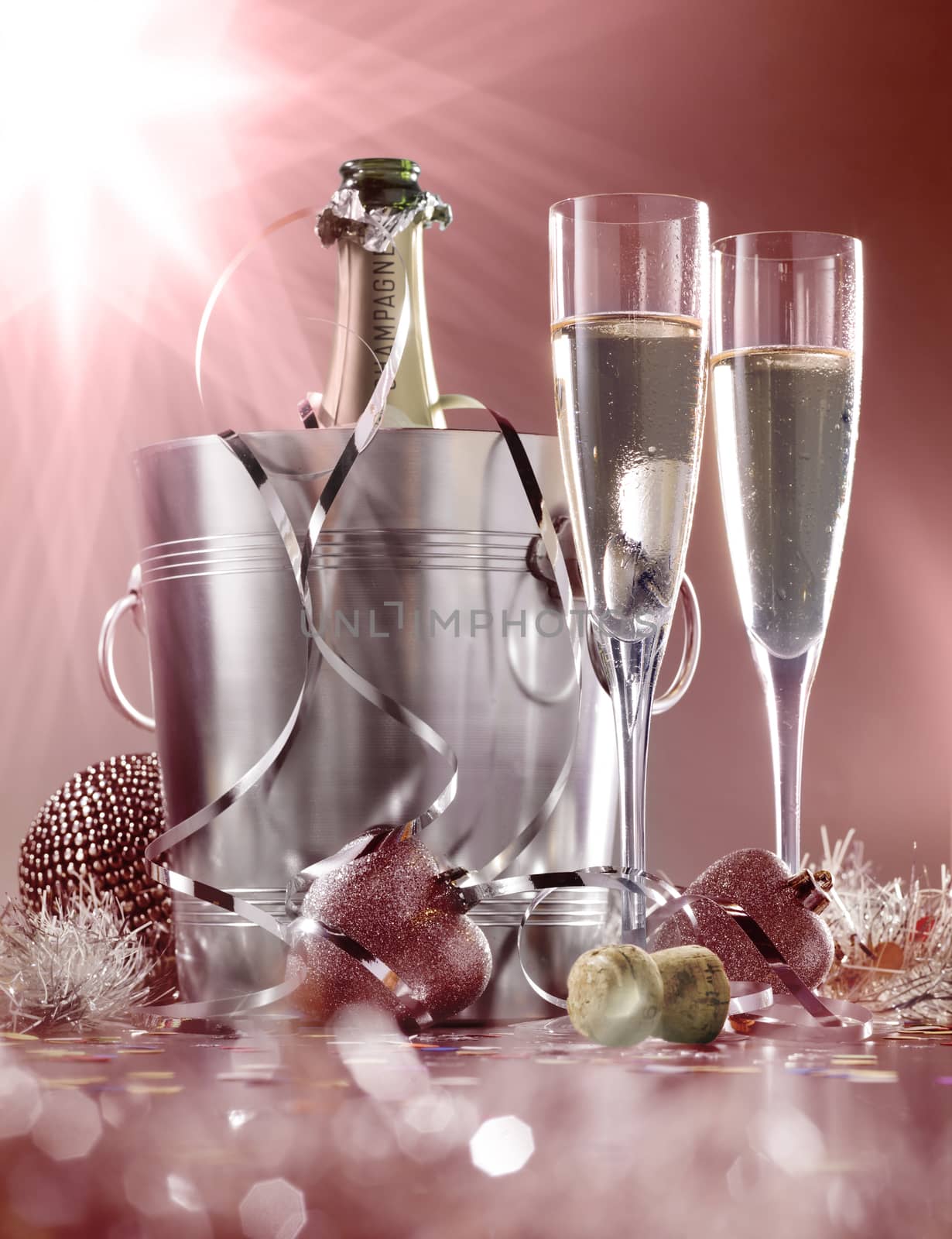 glasses of champagne with bottle in cooler on a red with white background