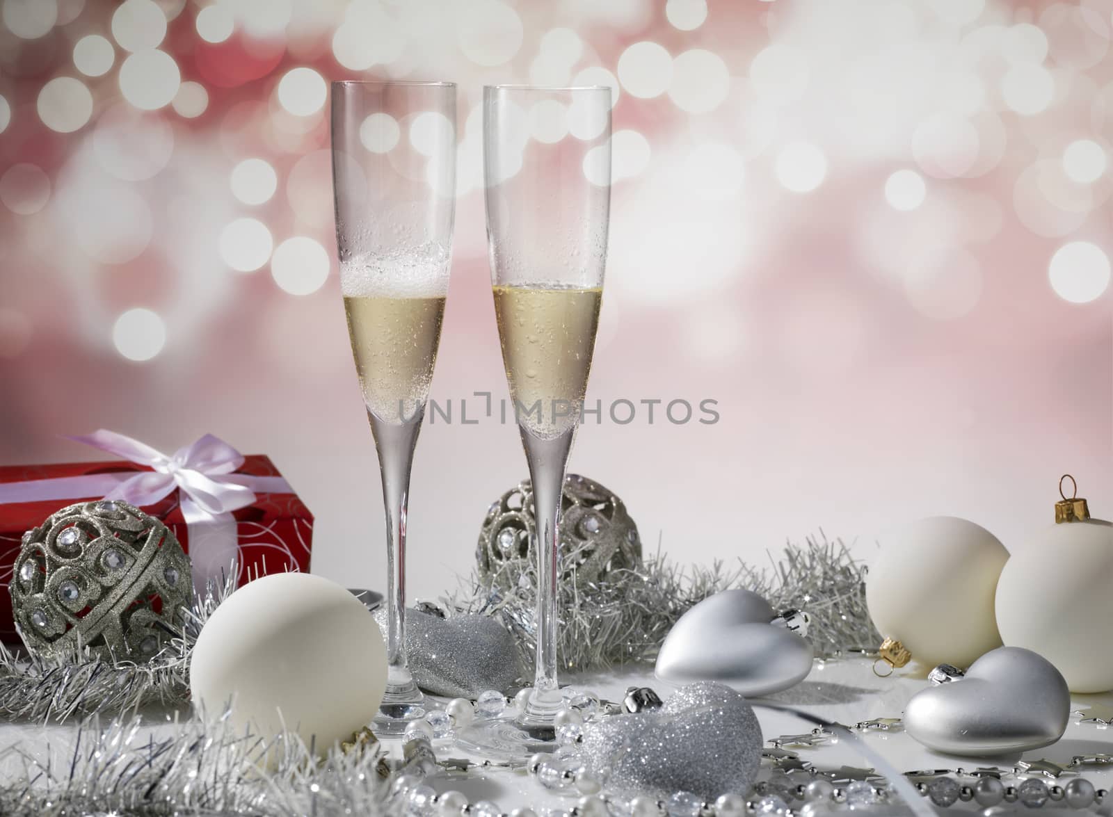 two glasses of champagne for christmas celebration with red decoration and gift