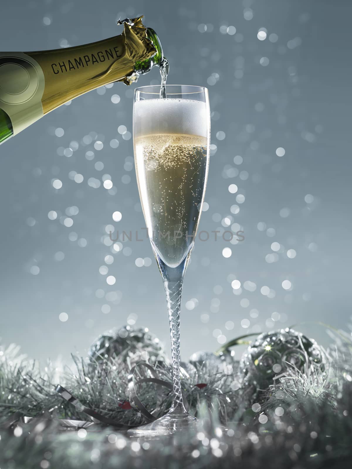 pouring champagne into the glass on a blue christmas background by janssenkruseproductions