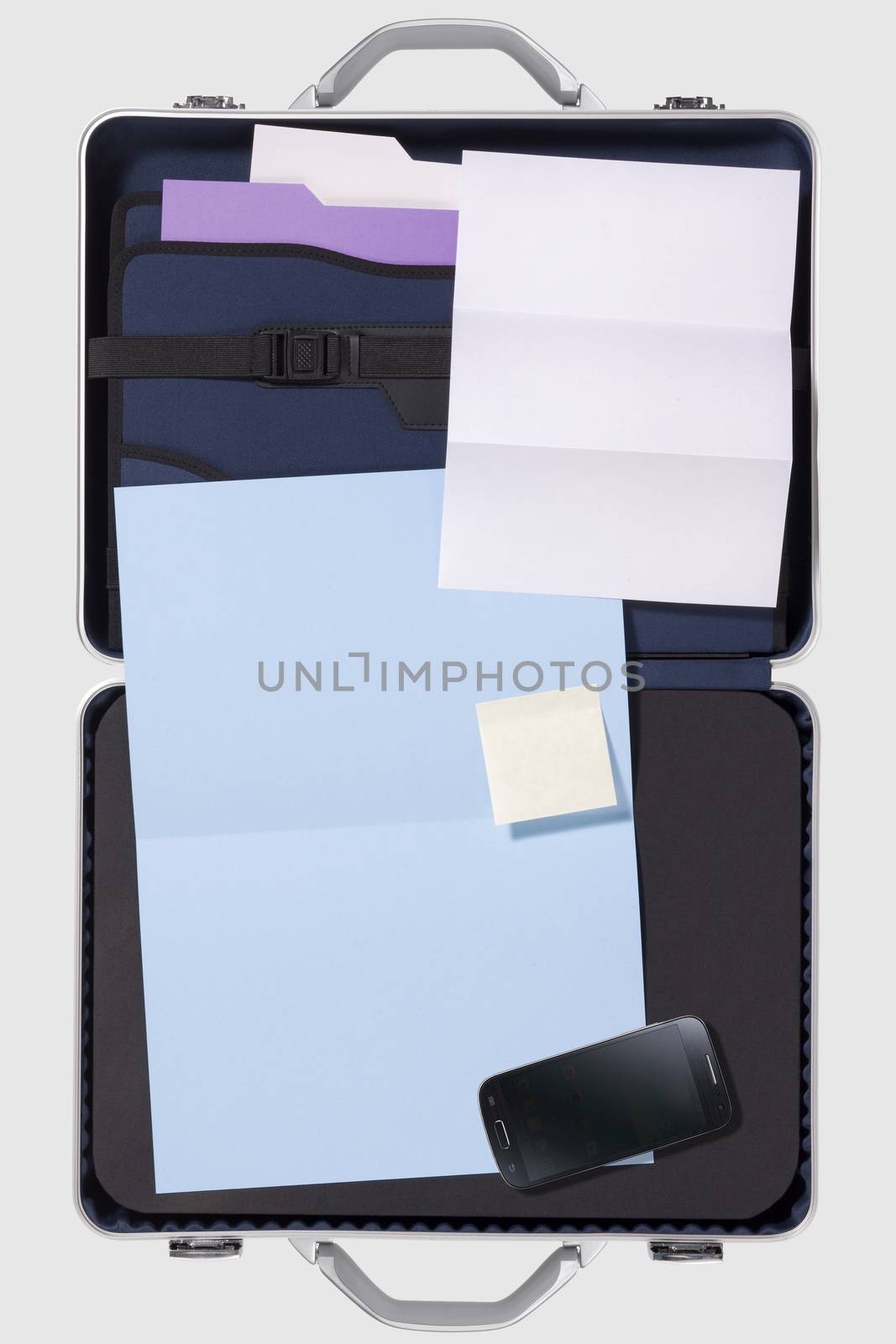 Businessman's briefcase on a white background with smartphone, financial report, newspaper and organizer