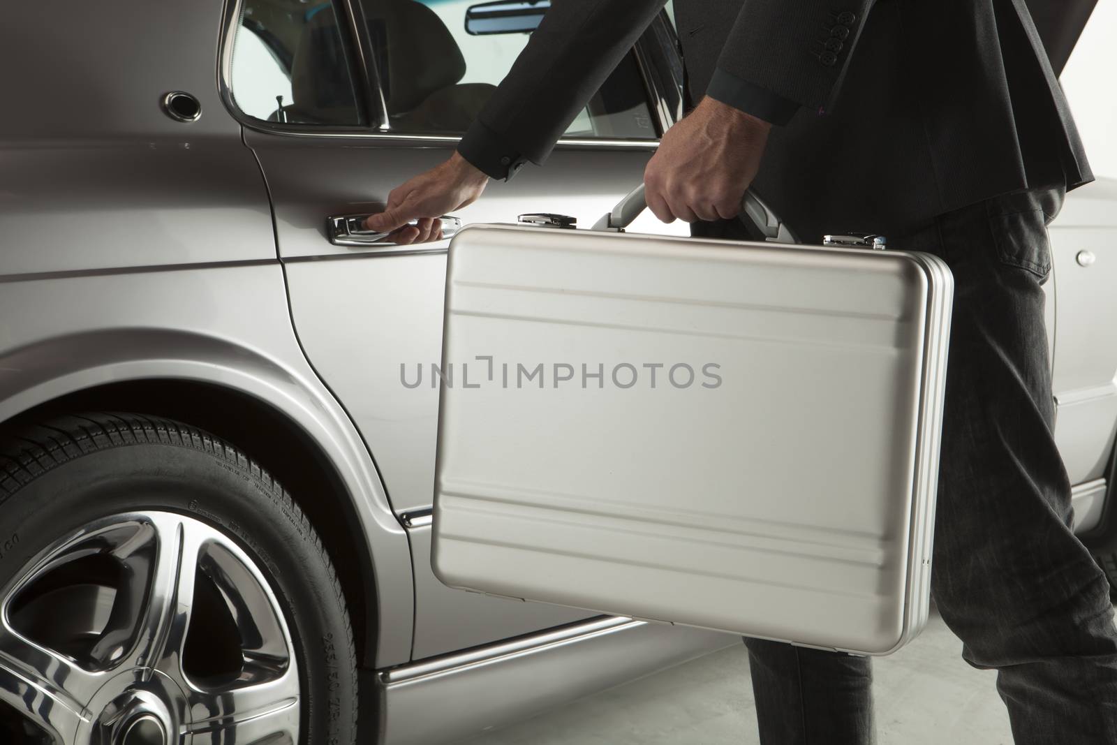 Hand on handle. Close-up of man in formalwear opening a car door with a briefcase
