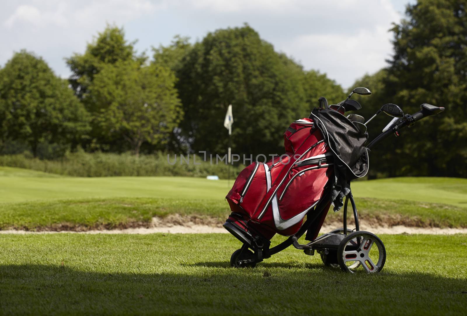  Golf bag with several clubs on a trolley on the fairway of a go by janssenkruseproductions