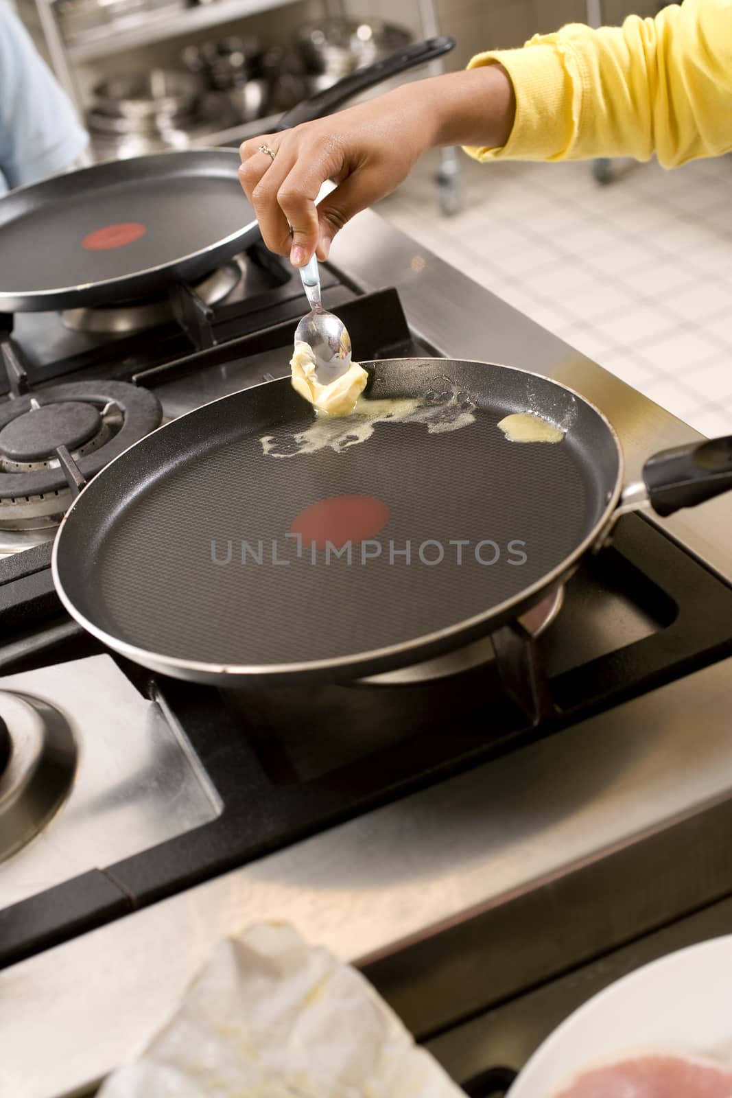 Woman melting the butter in the frying pan by janssenkruseproductions