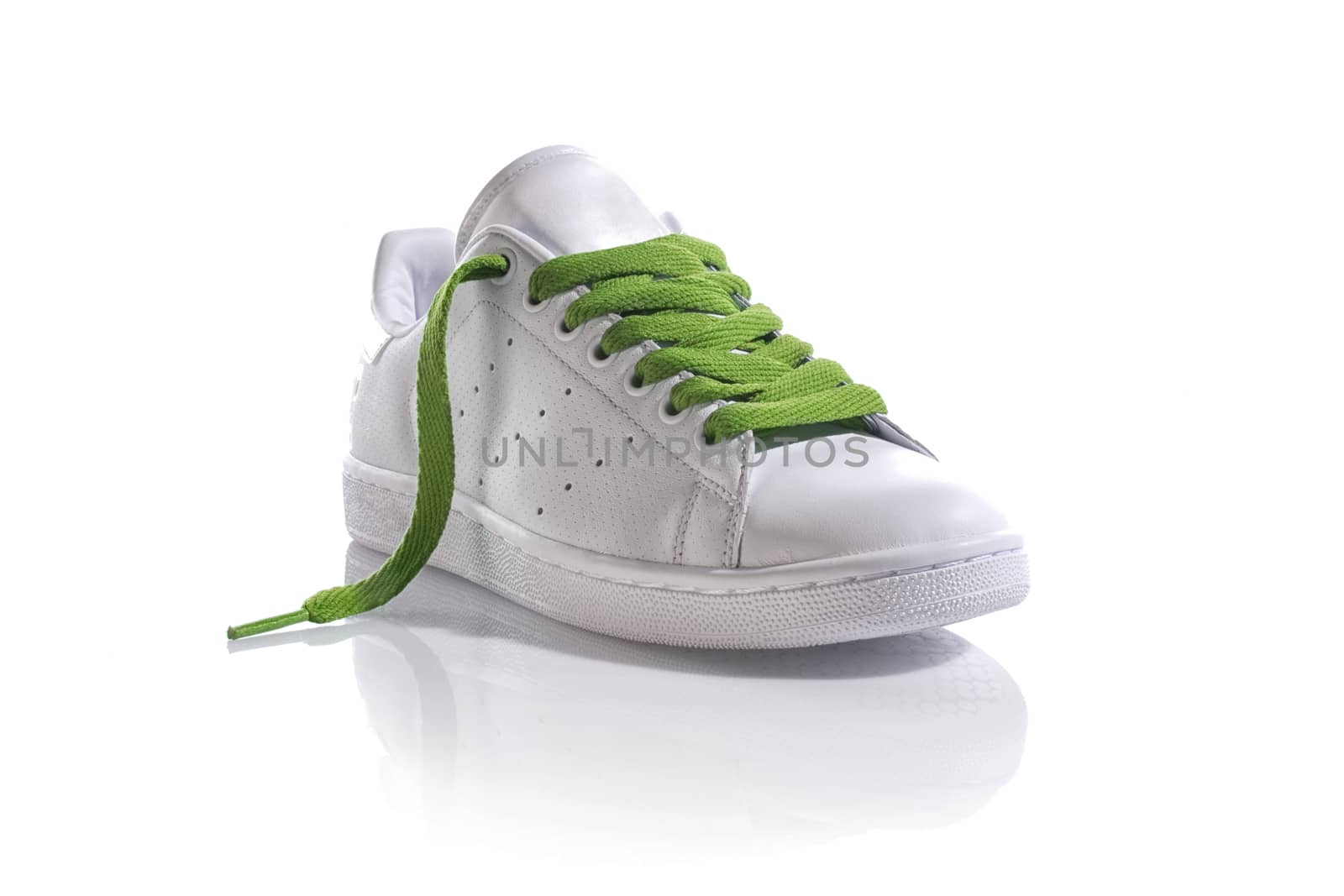 White sneaker with green laces on white background