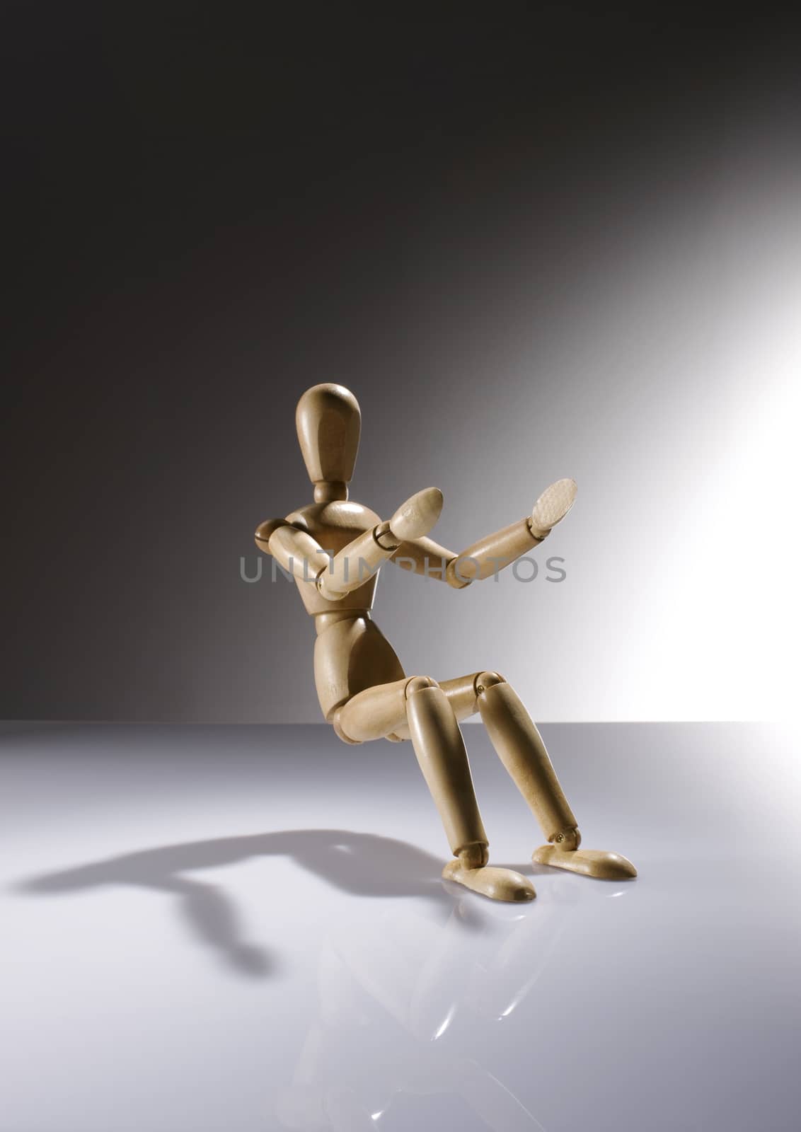 Wooden Dummy Doll sitting without a chair on gradient background