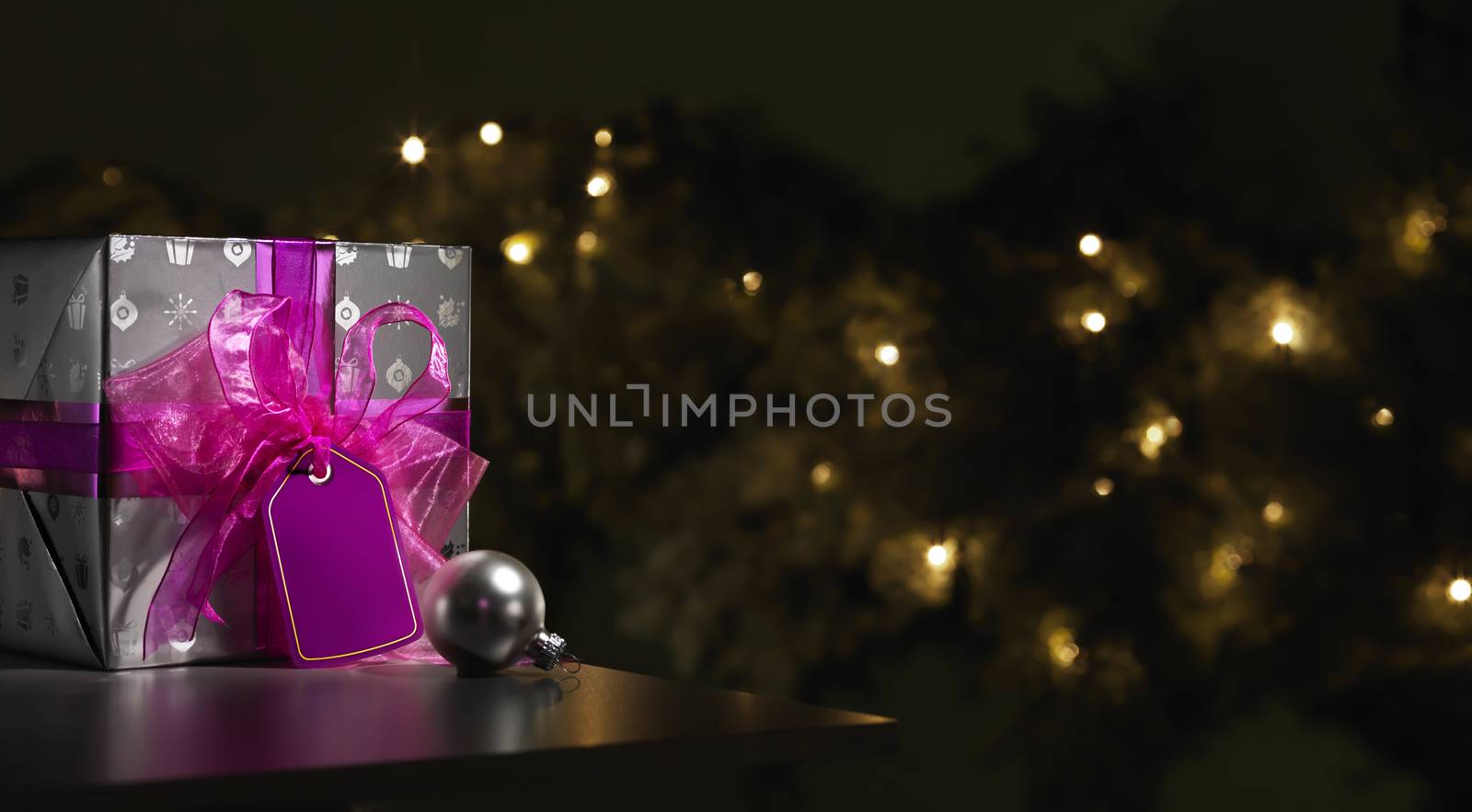 Purple Christmas gift with a tree in the background