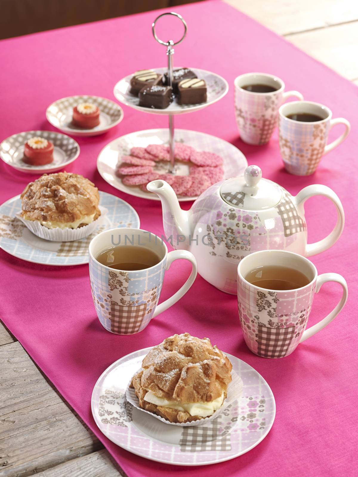 High tea birthday party table setting with food and a pink table