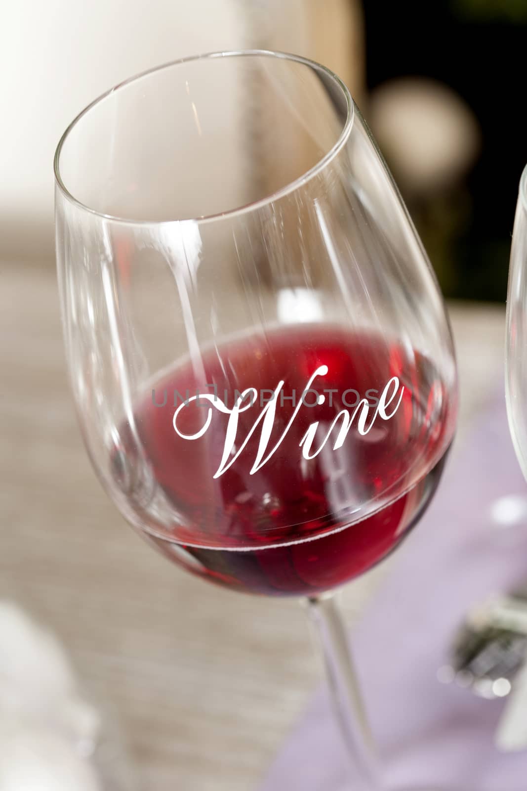 Wineglass with red wine on a diner table by janssenkruseproductions