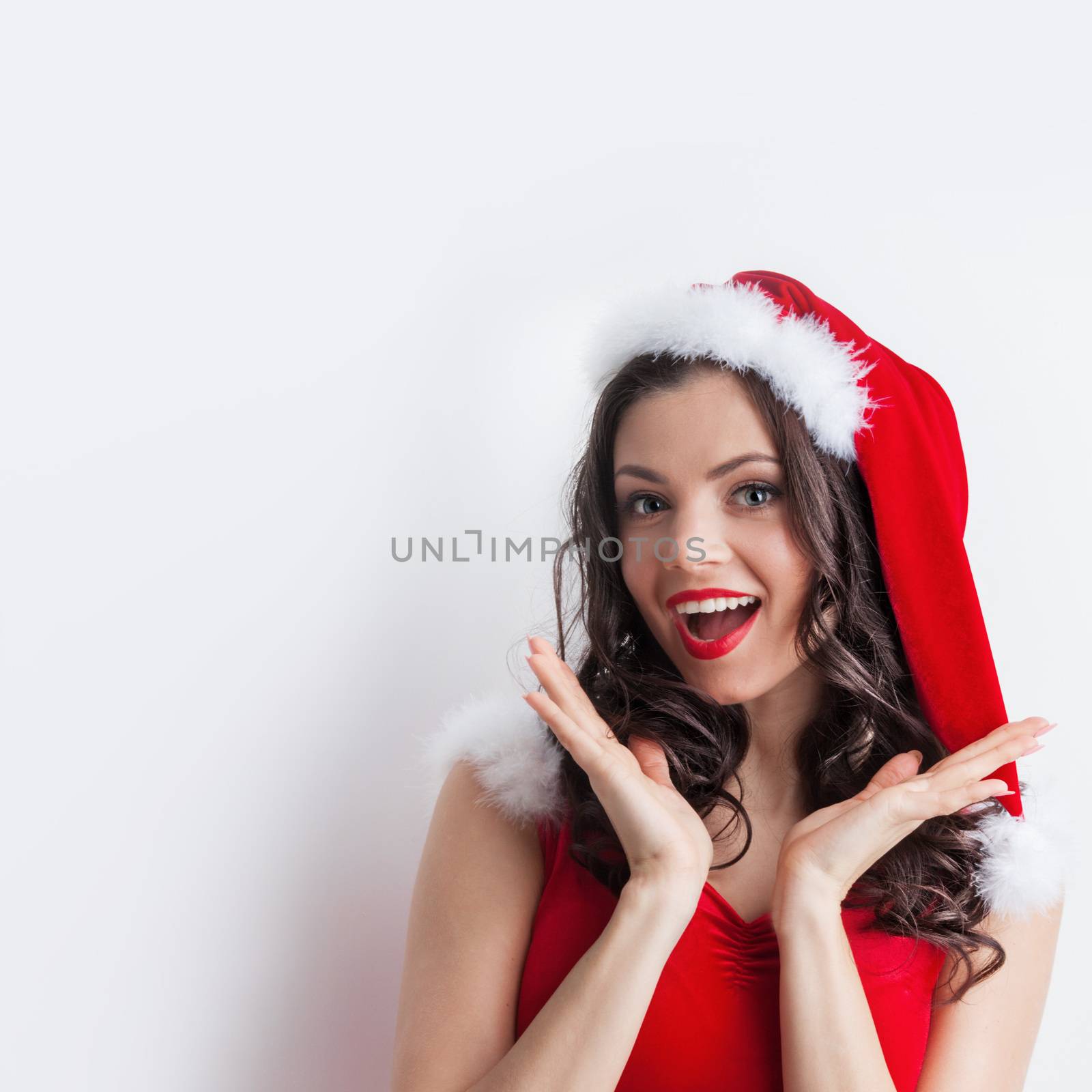 Pretty Pin-up style Santa girl in red hat on white background
