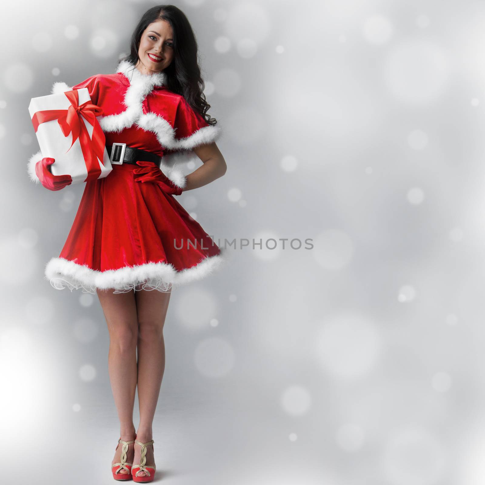 Beautiful woman wearing santa claus costume with gift