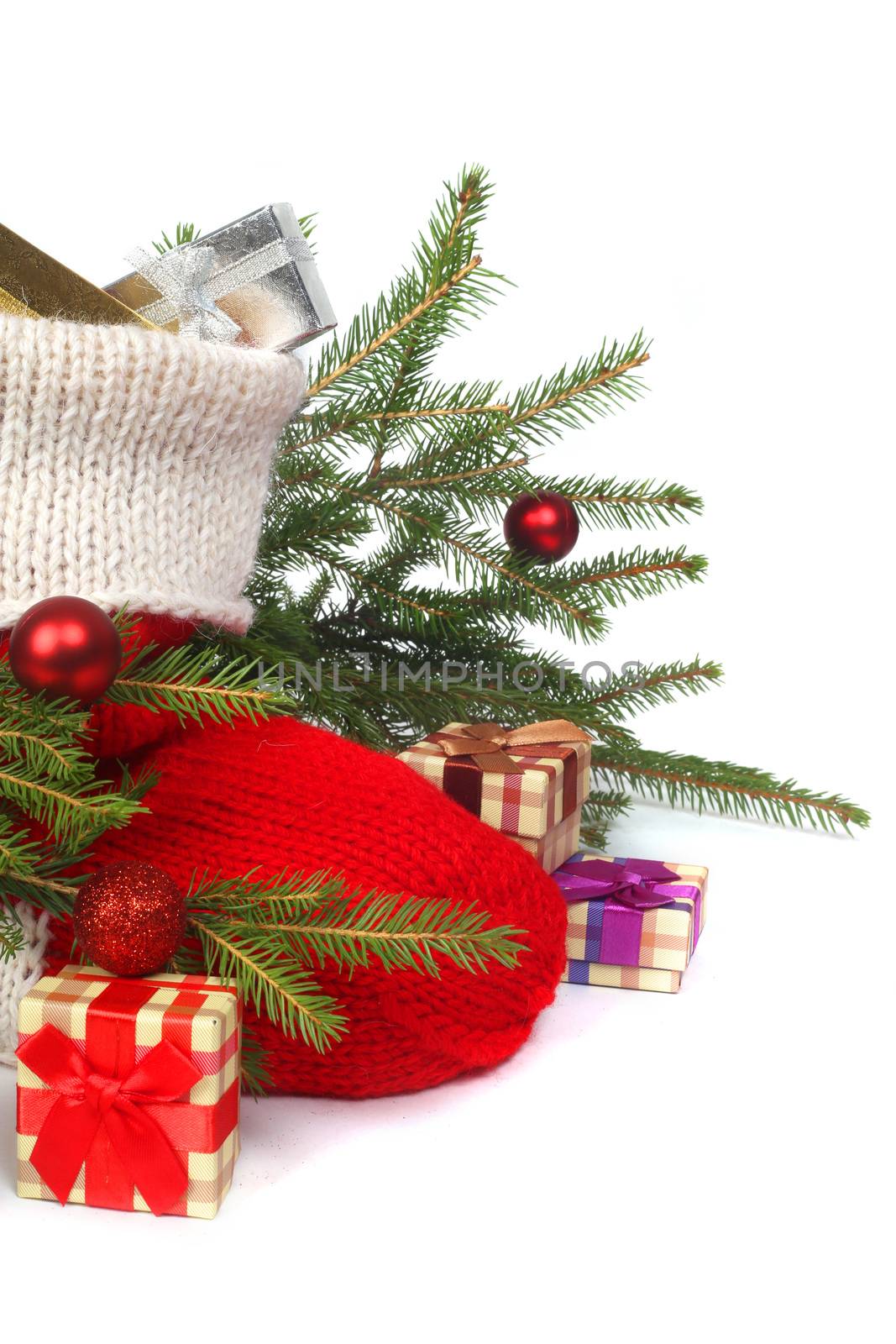 Red Christmas sock with gifts and decorated fir branch isolated on white background