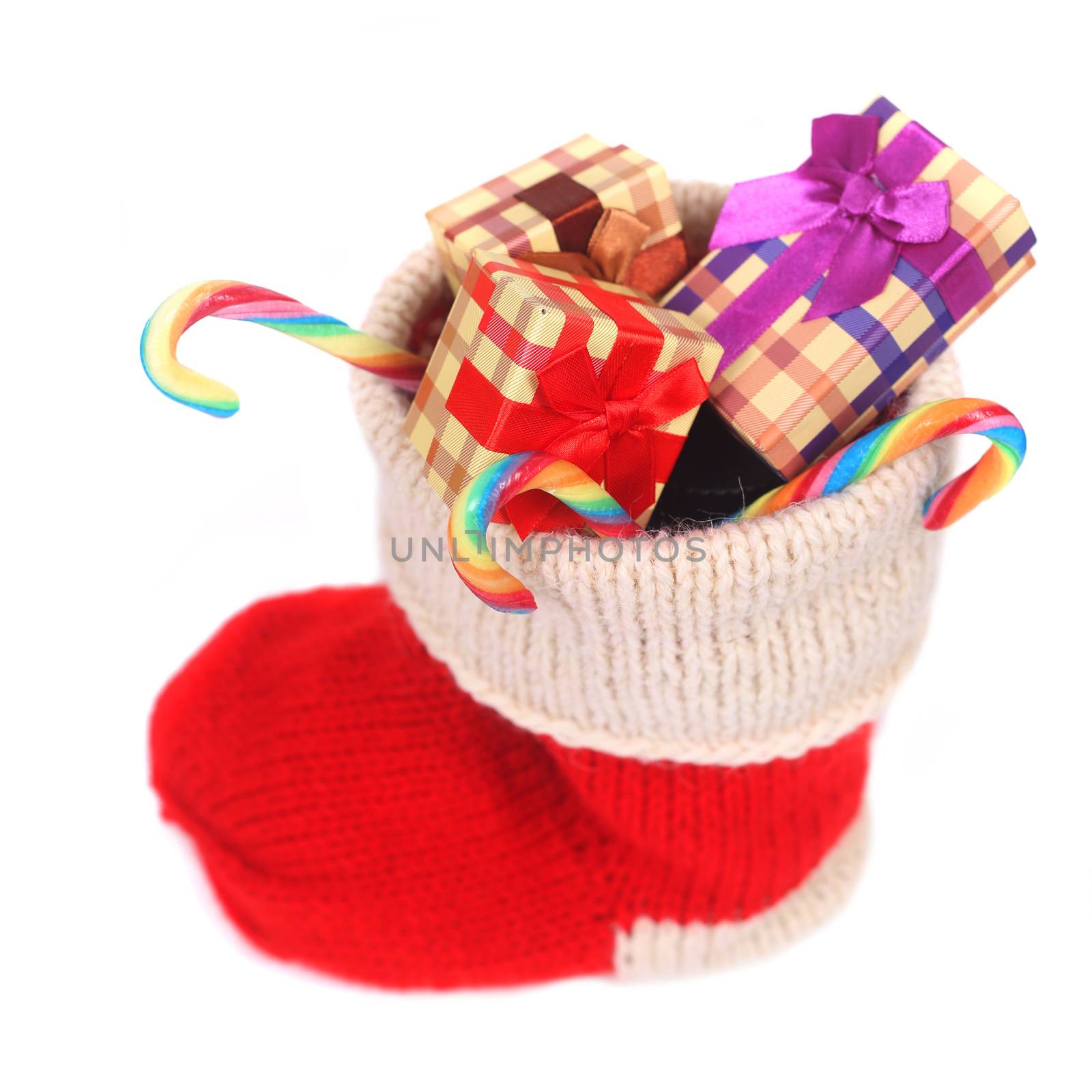 Red Christmas sock with gifts and candy isolated on white background