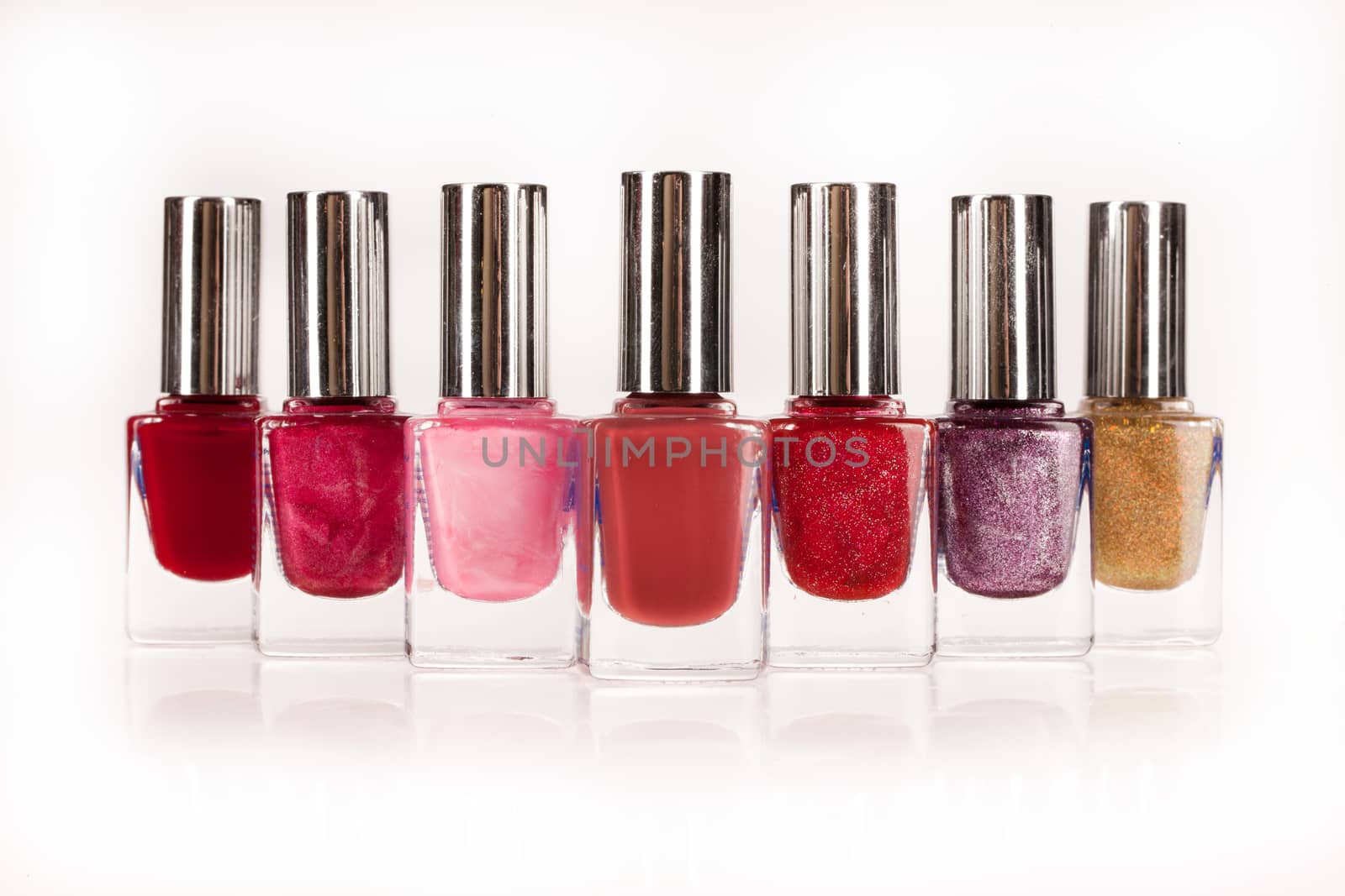 Little bottles with enamel on an isolated studio background