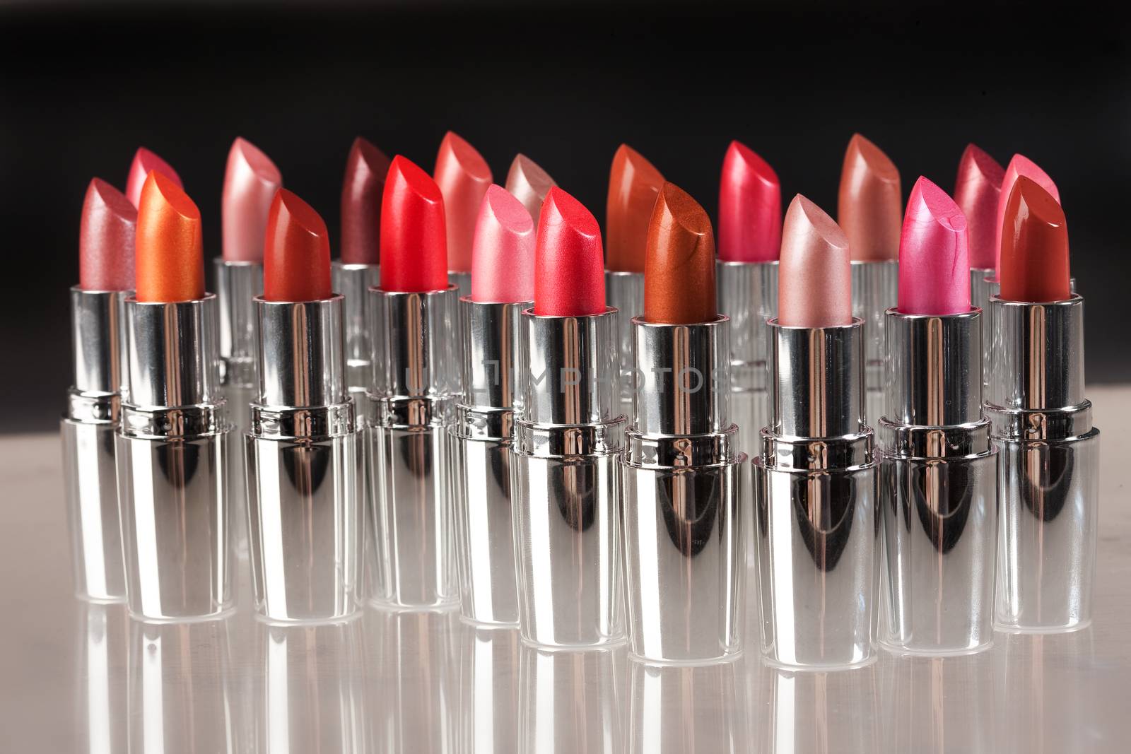 Tubes with different kinds of lipstick on studio background