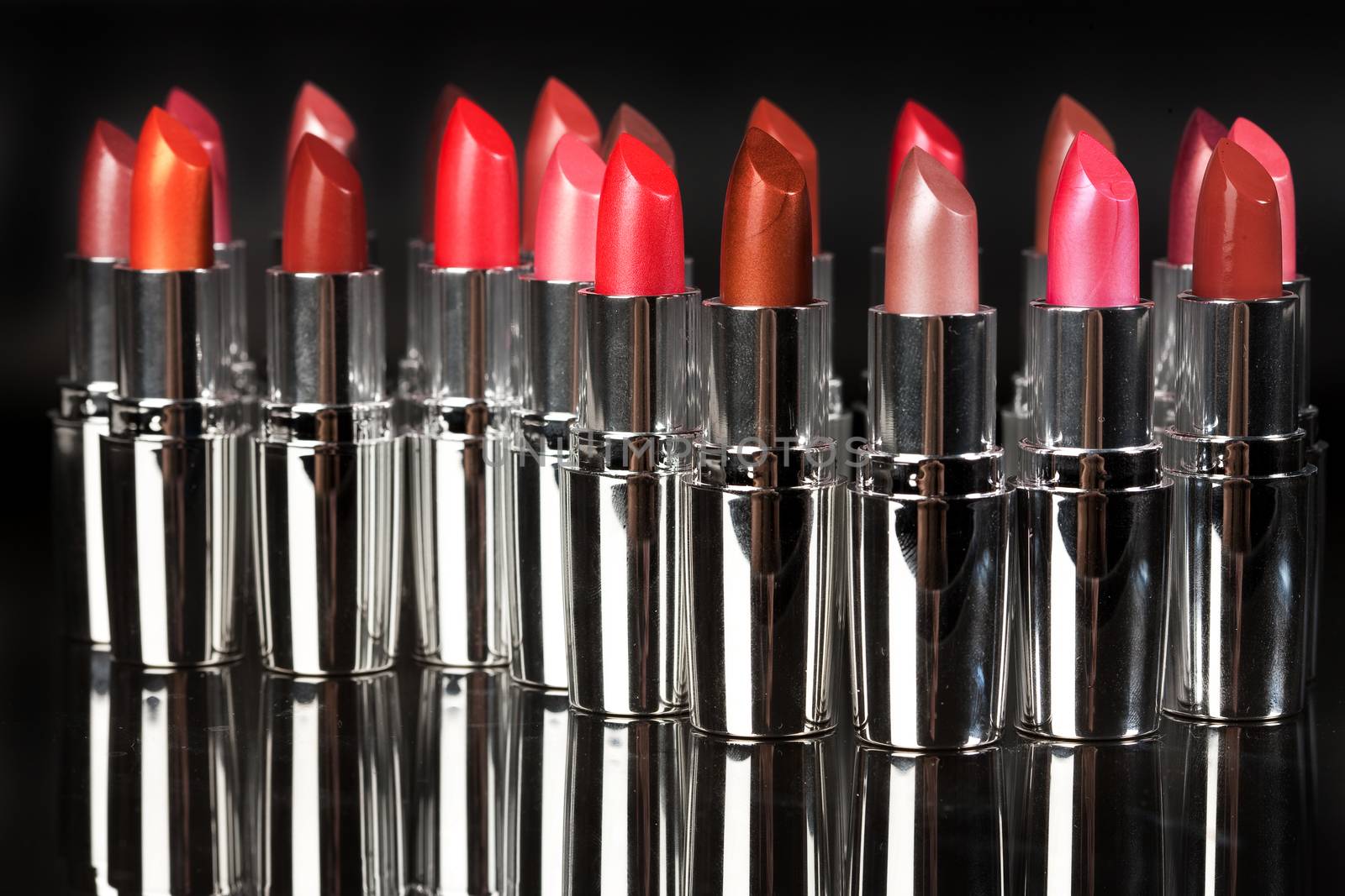 Tubes with different kinds of lipstick on studio background