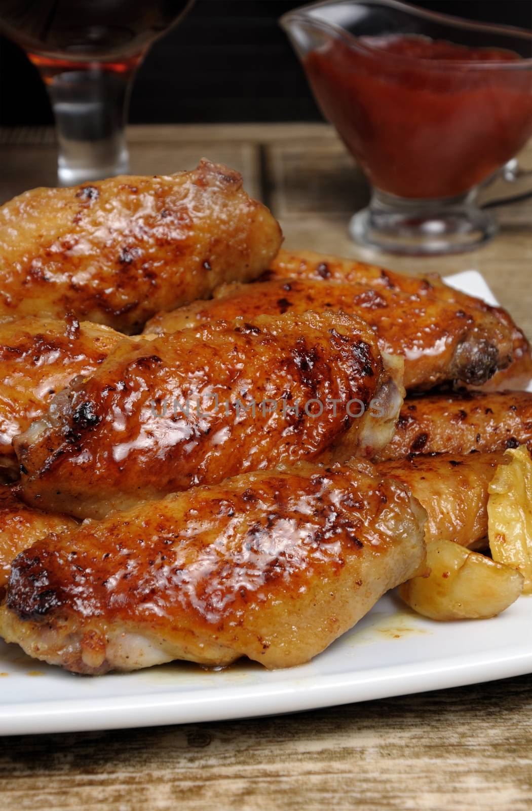 Fried sharply spicy chicken wings on a baking c sauce