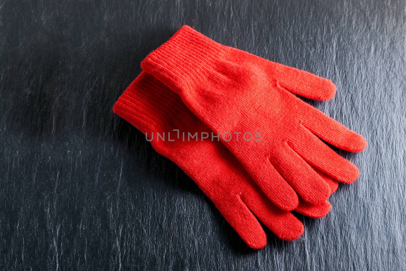 Women's Red gloves placed on black background