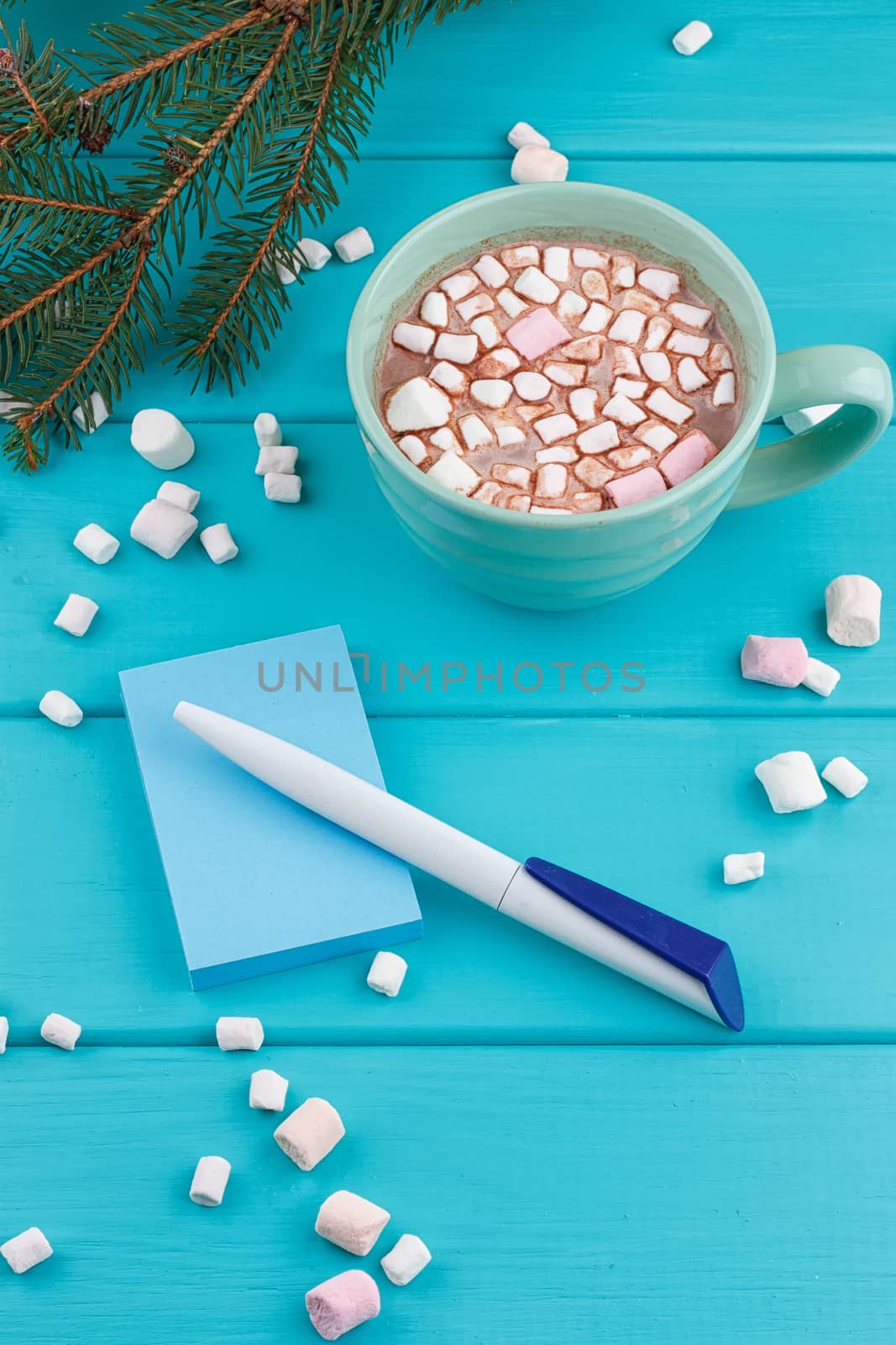 hot cocoa with marshmallows with pen and notepad