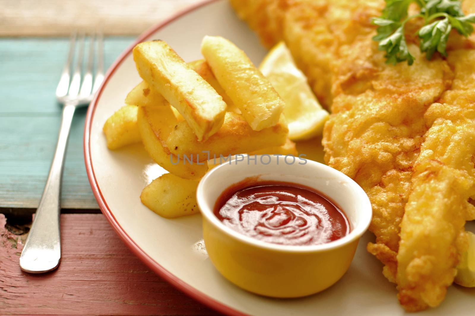 Deep fried battered fish on a plate with chips close up