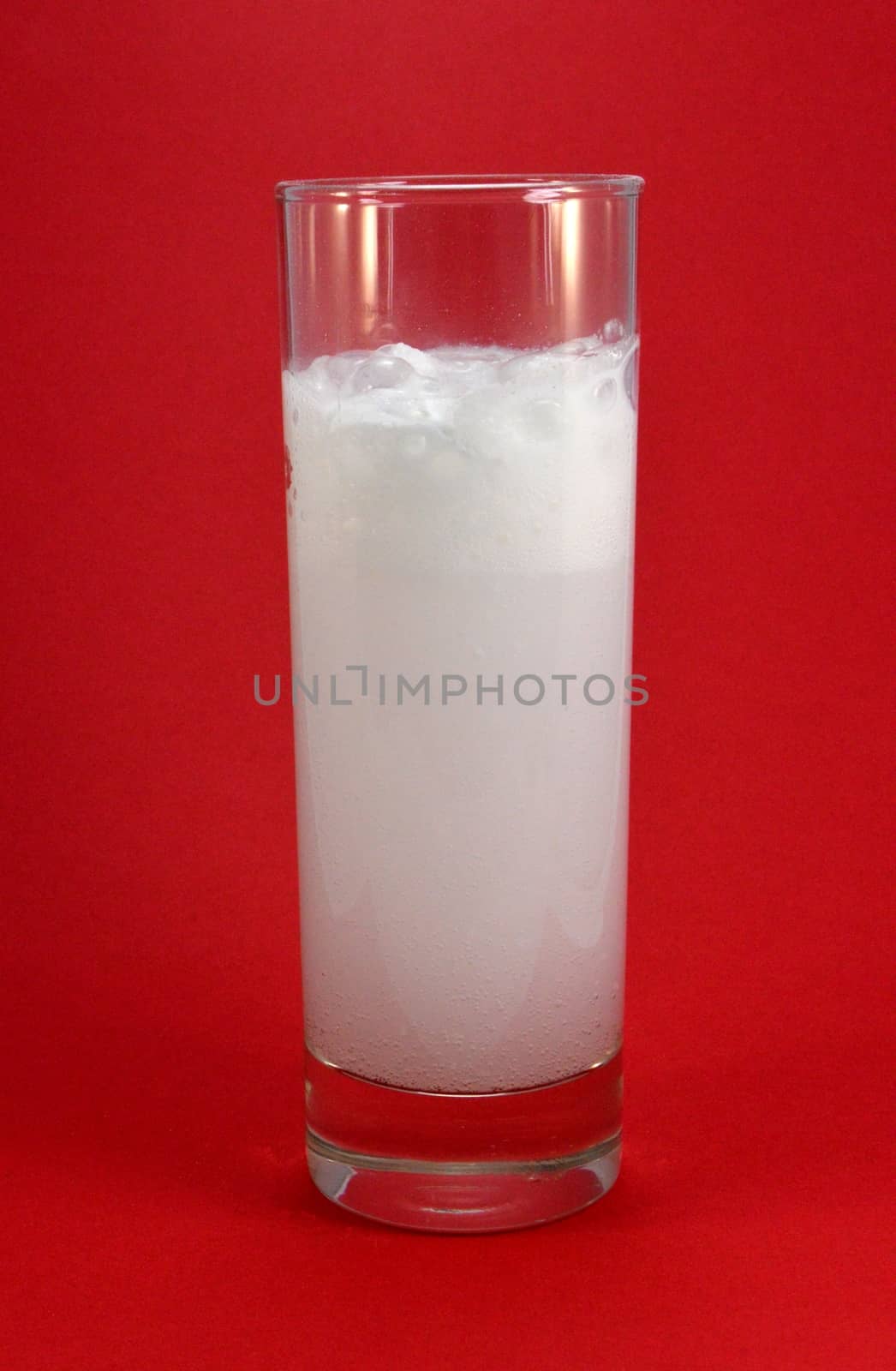 Long drink glass containing water with an effervescent agent