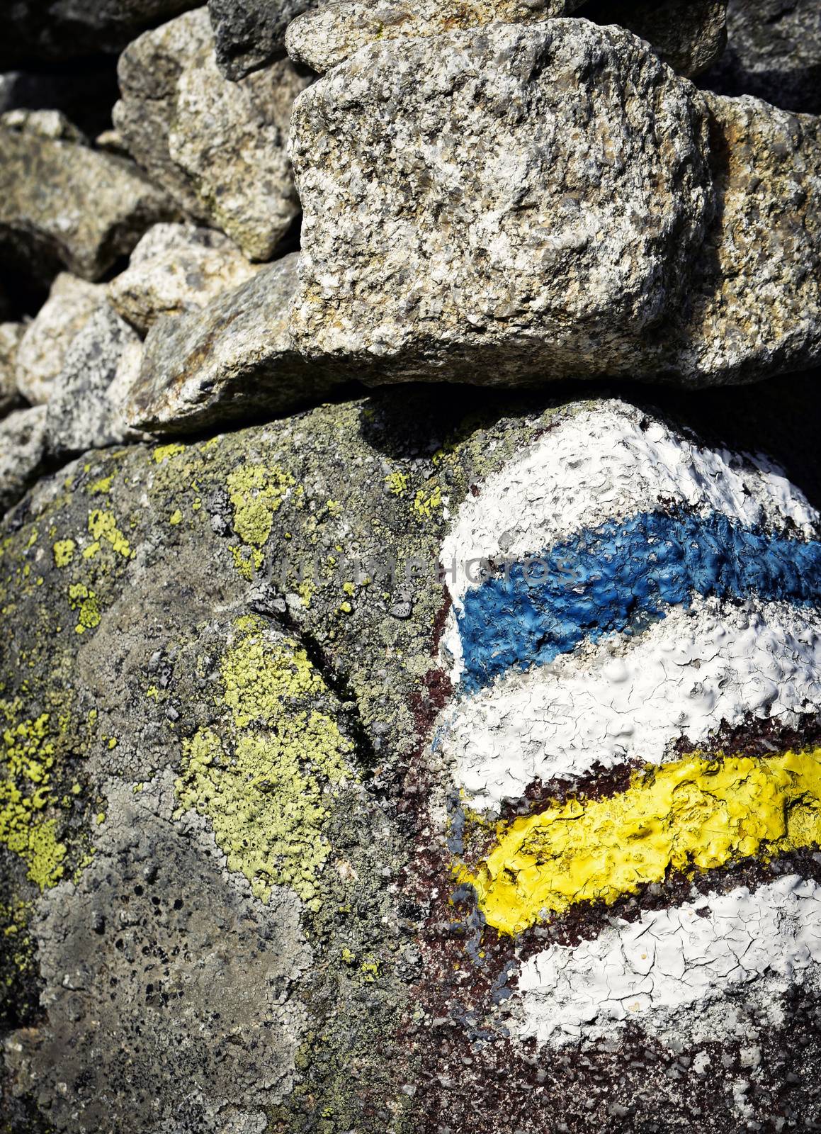 blue and yellow Tourist signs on the stone