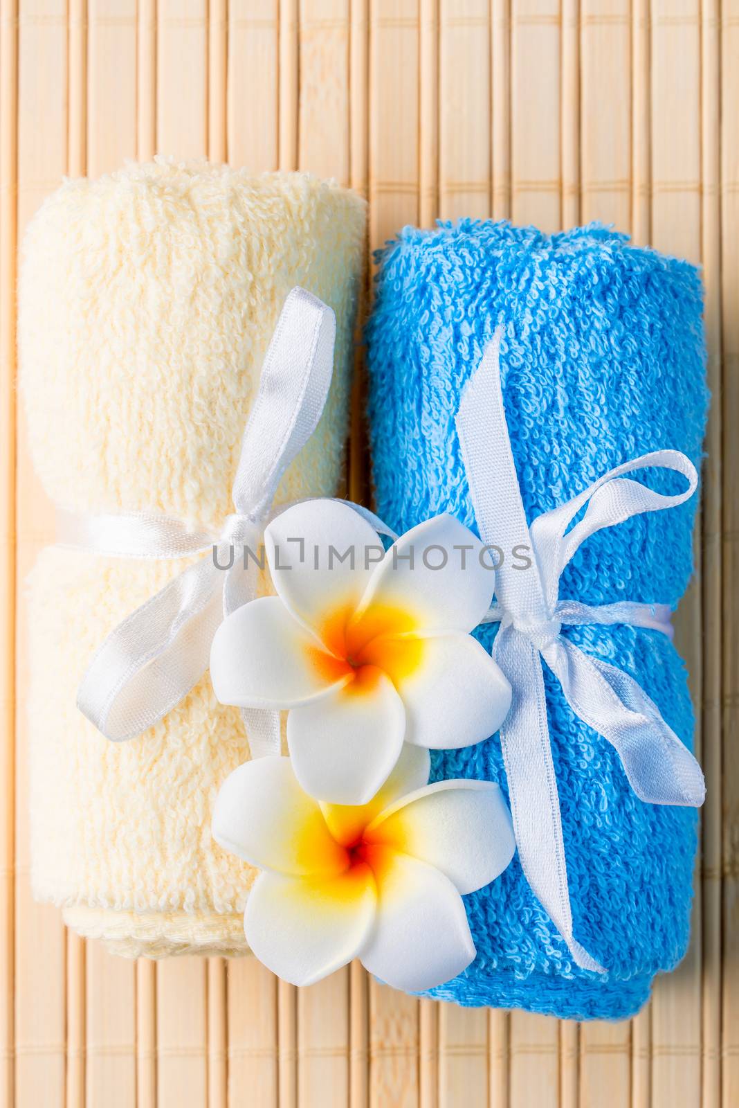 terrycloth towels and exotic flowers for spa treatments closeup by kosmsos111
