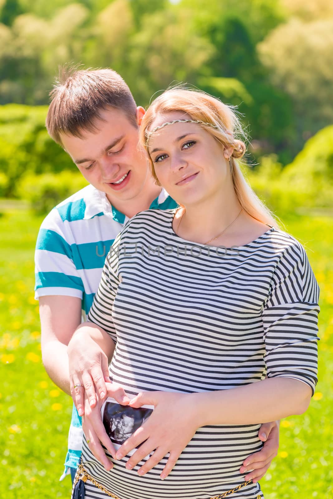 young parents holding photos, with the result Uzi near the abdomen