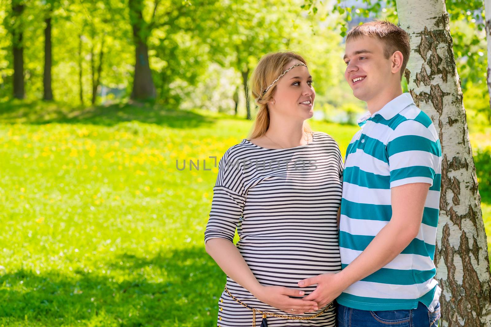 future parents couple posing in the summer park