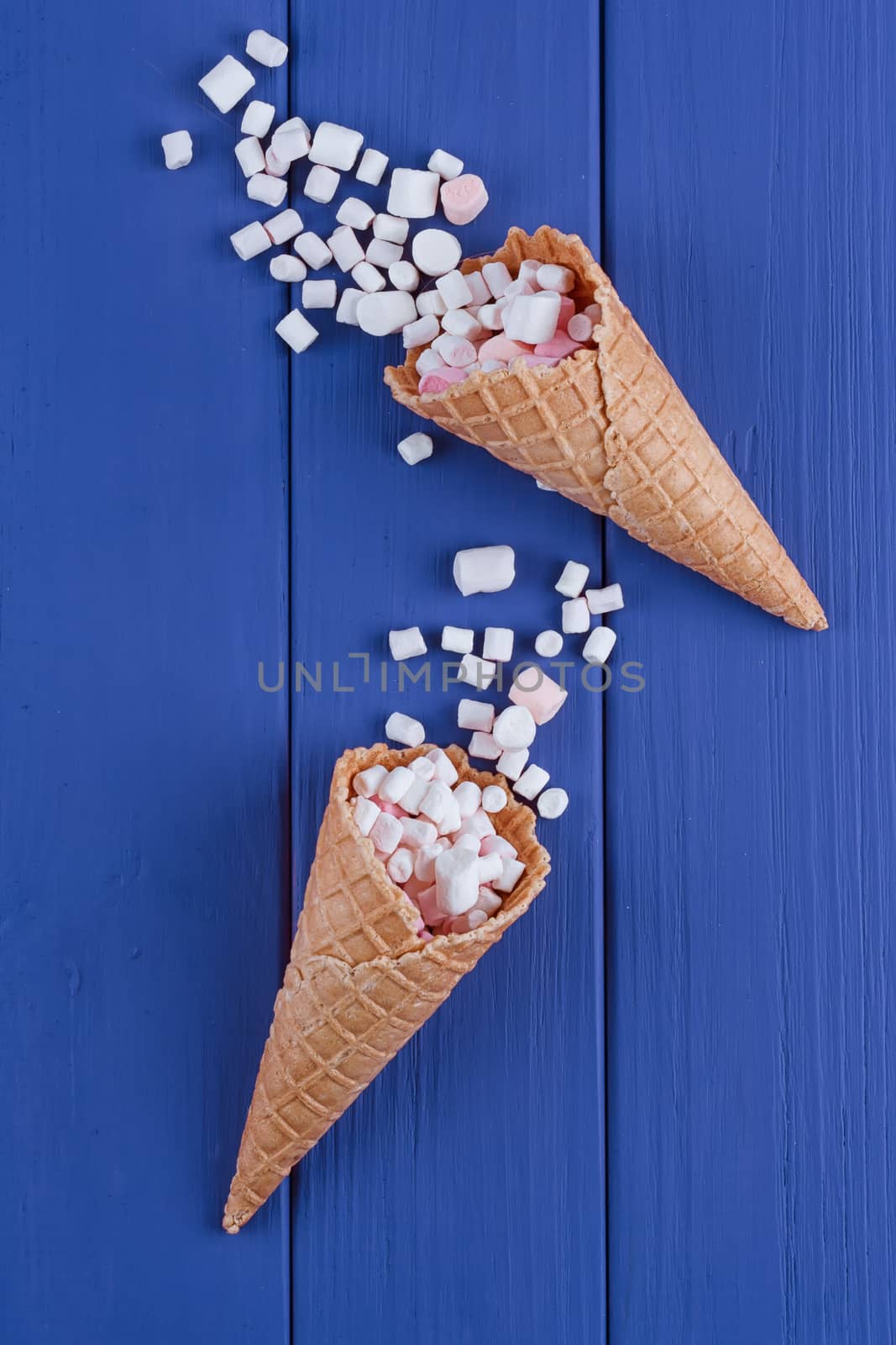 Marshmallows ice-cream and waffle cones on a blue background