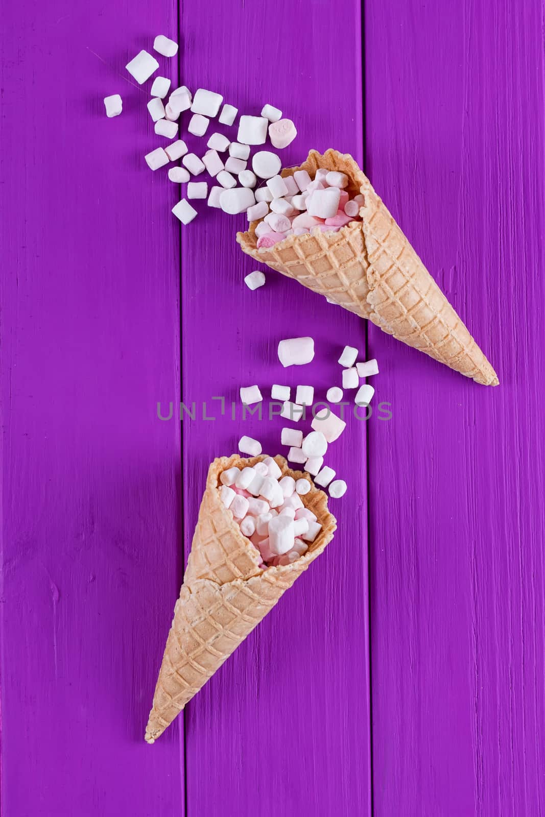 Marshmallows ice-cream and waffle cones on a purple background