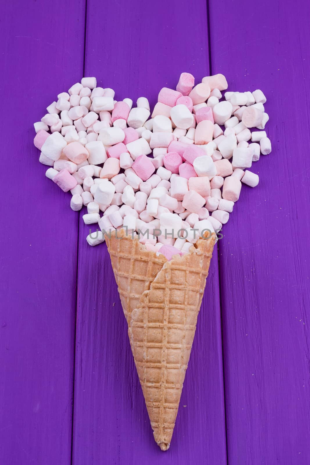 Marshmallows heart and waffle cones on a purple background
