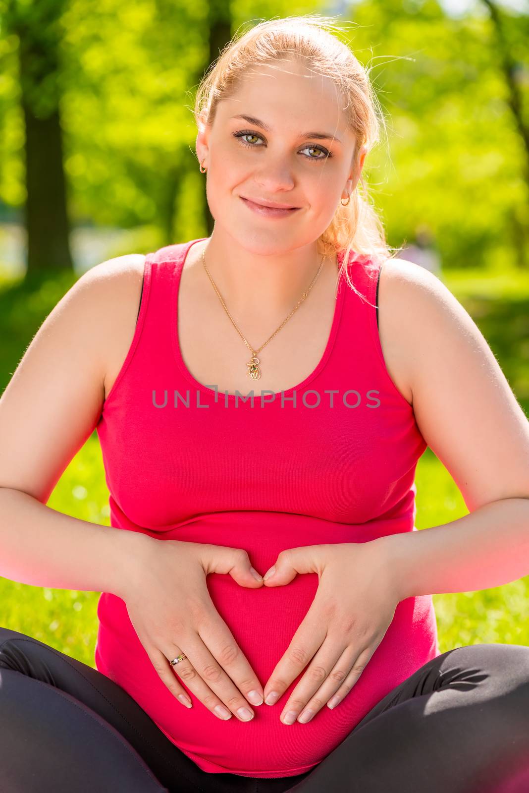 Vertical portrait of a happy expectant mother in the park