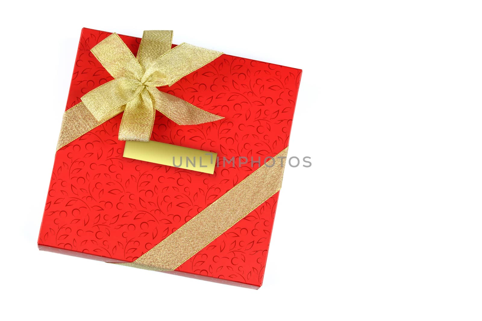 Red gift with blank label and decorated with gold ribbon isolated on a white background