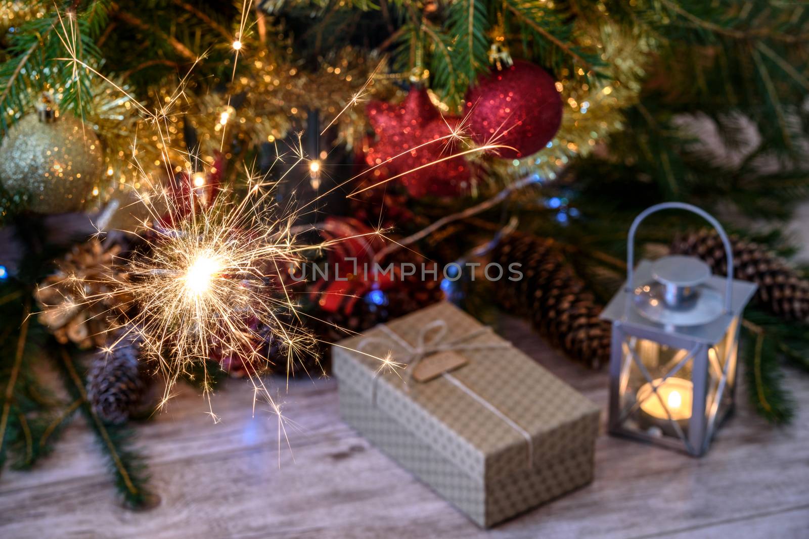 Sparklers and a gift with Christmas tree and lights
