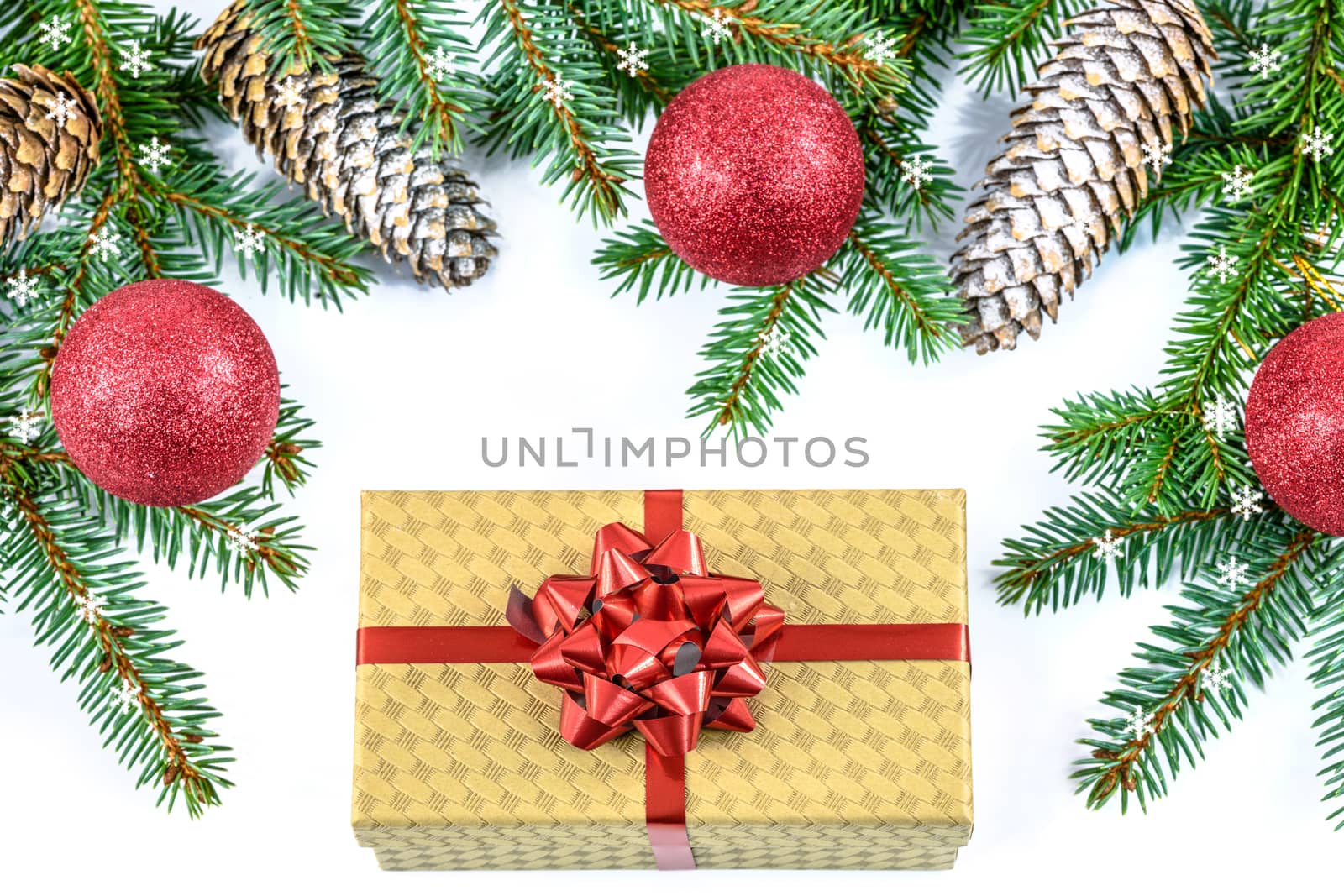 Overhead shot on branches of Siberian spruce and elegant cardboard box decorated with a red ribbon isolated on a white background