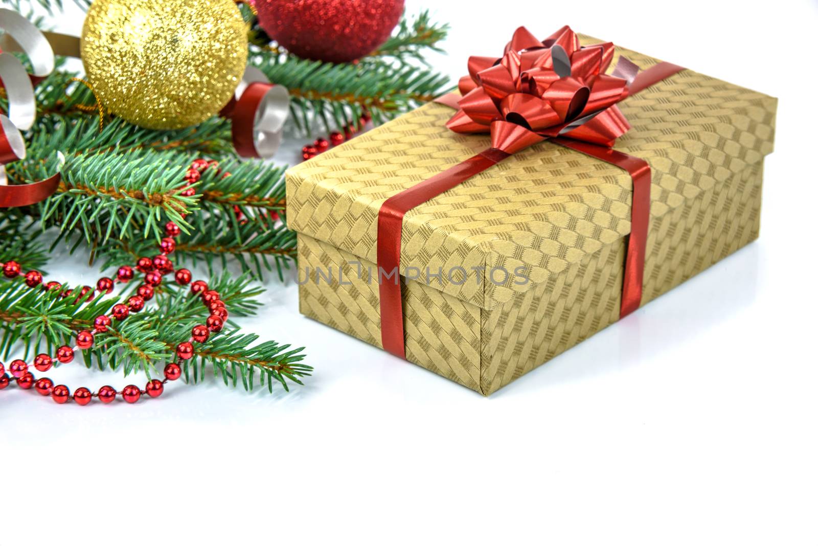Elegant Christmas gift decorated with a red ribbon with a Christmas decoration isolated on white background