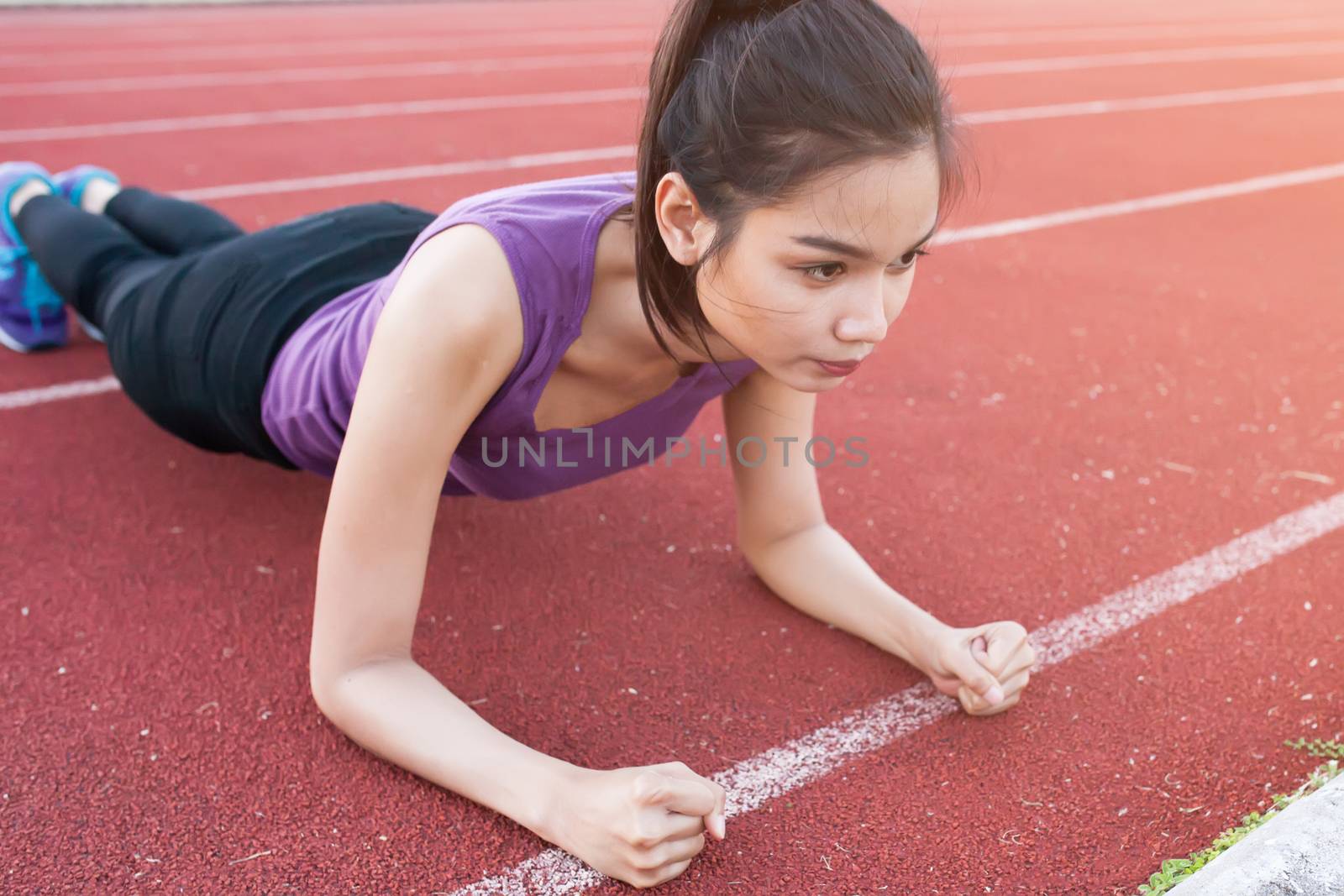 Sport urban Young athletic woman doing push-ups. Muscular and st by nopparats