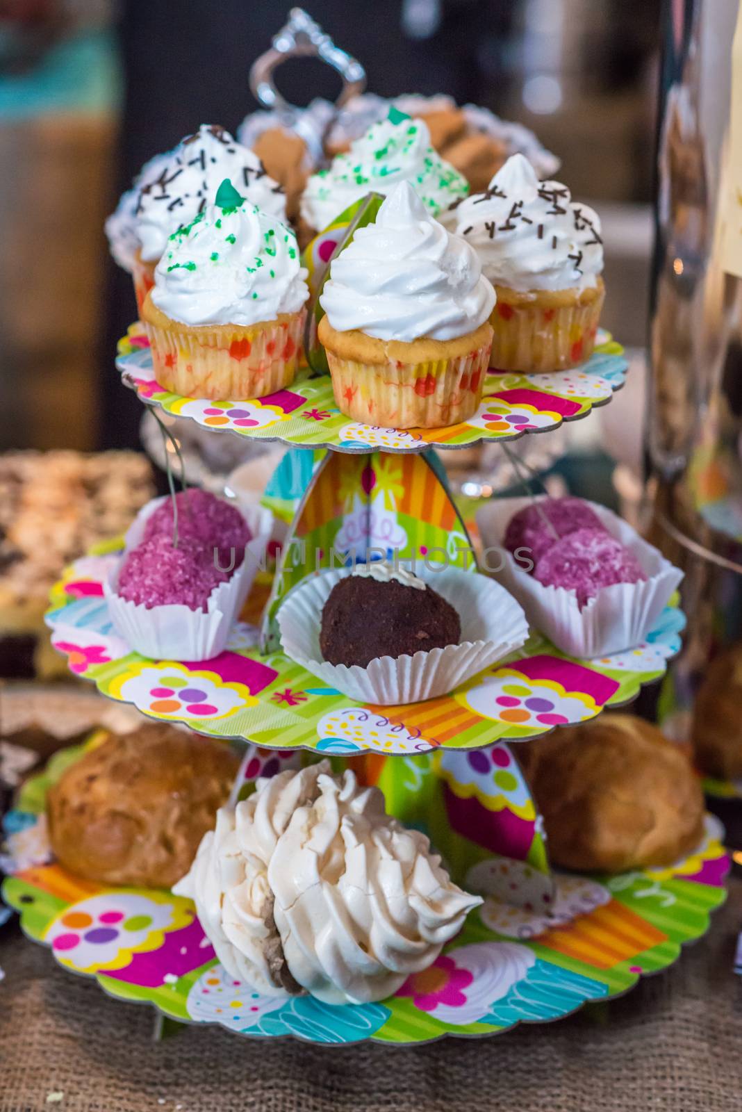 cupcakes and cakes on plates in three floors